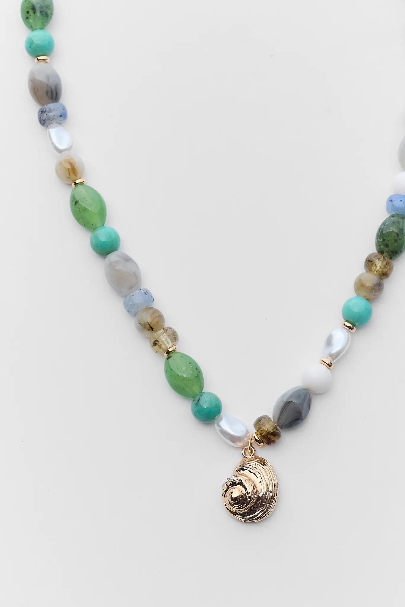 Necklace with multicolored beads and a gold clasp on a light background