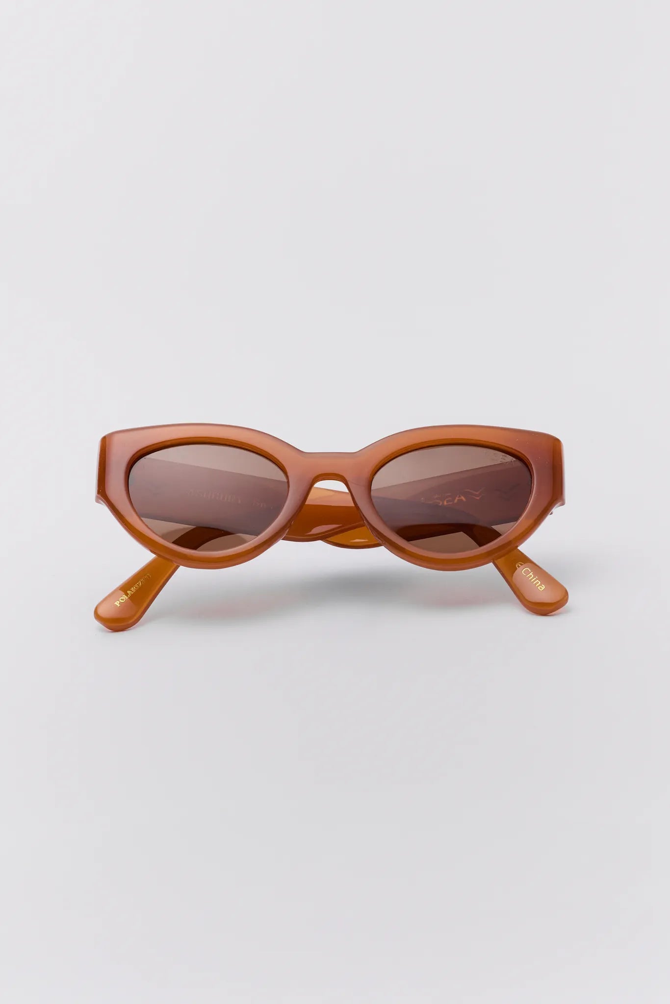 Brown sunglasses on a light gray background