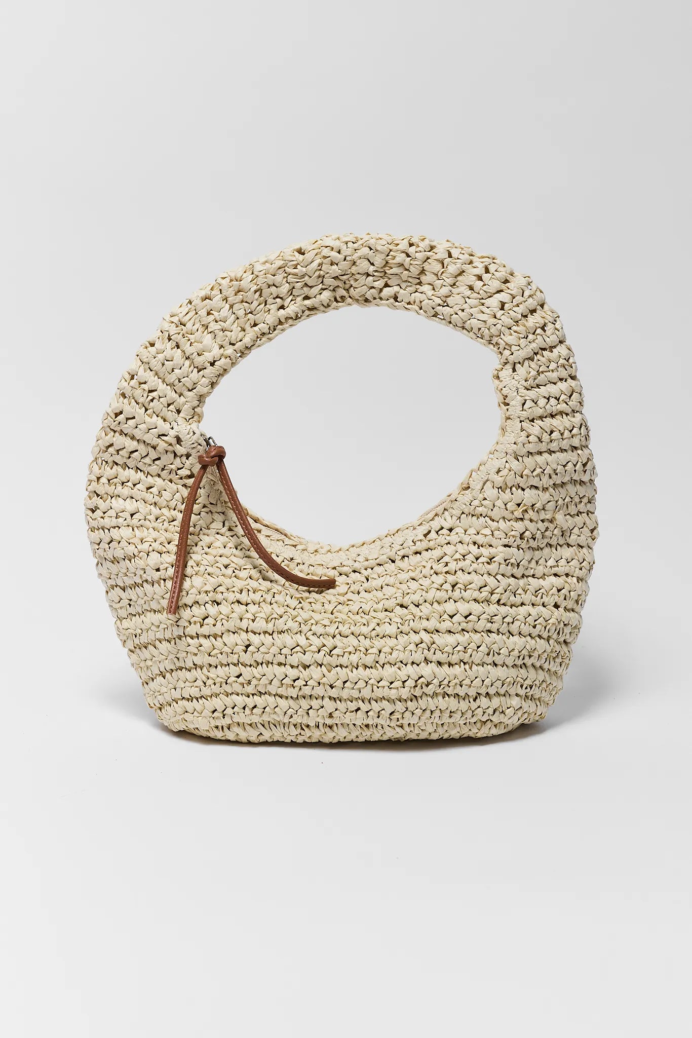 Woven straw handbag with a brown handle on a light gray background