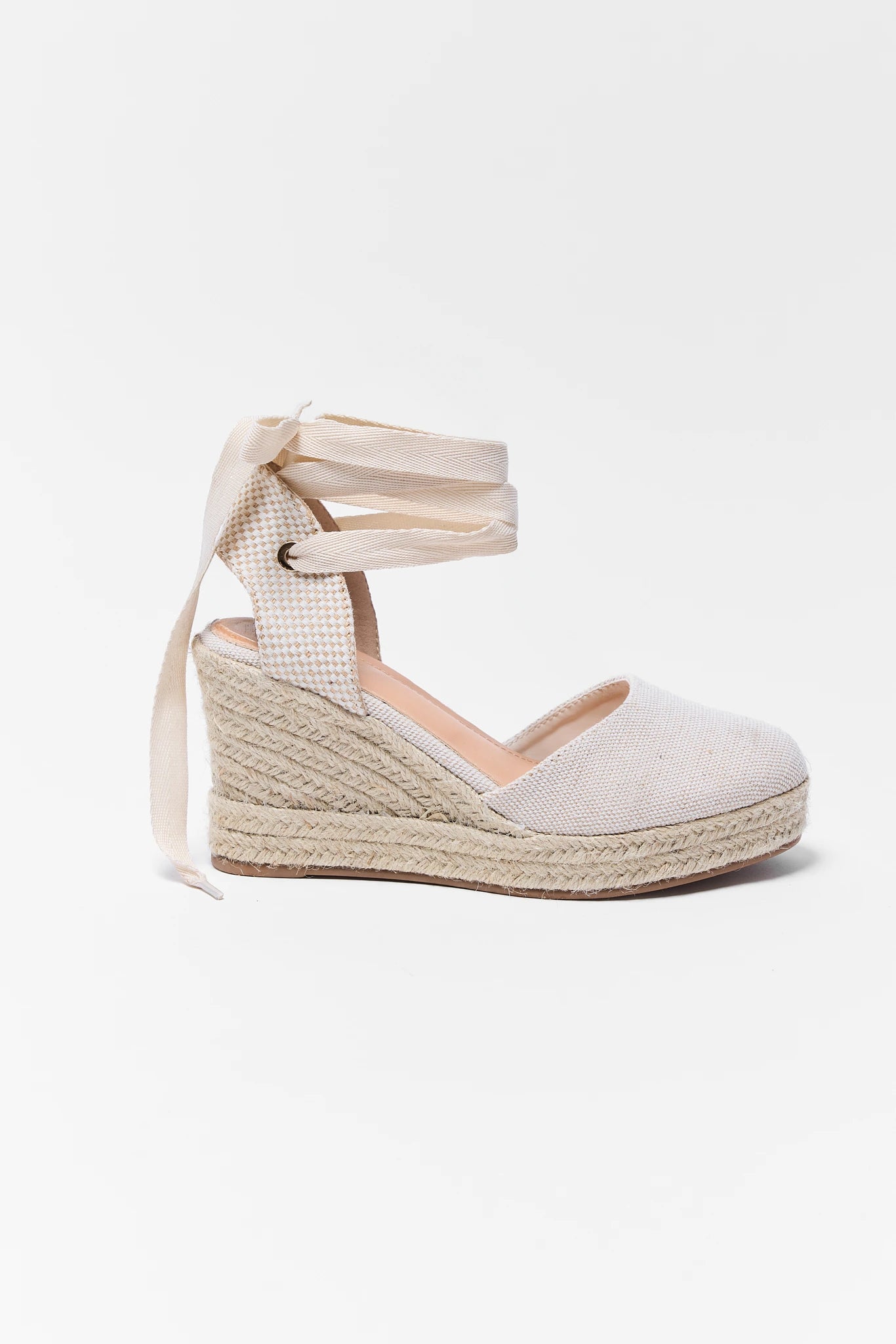 White wedge sandal with espadrille sole on a white background