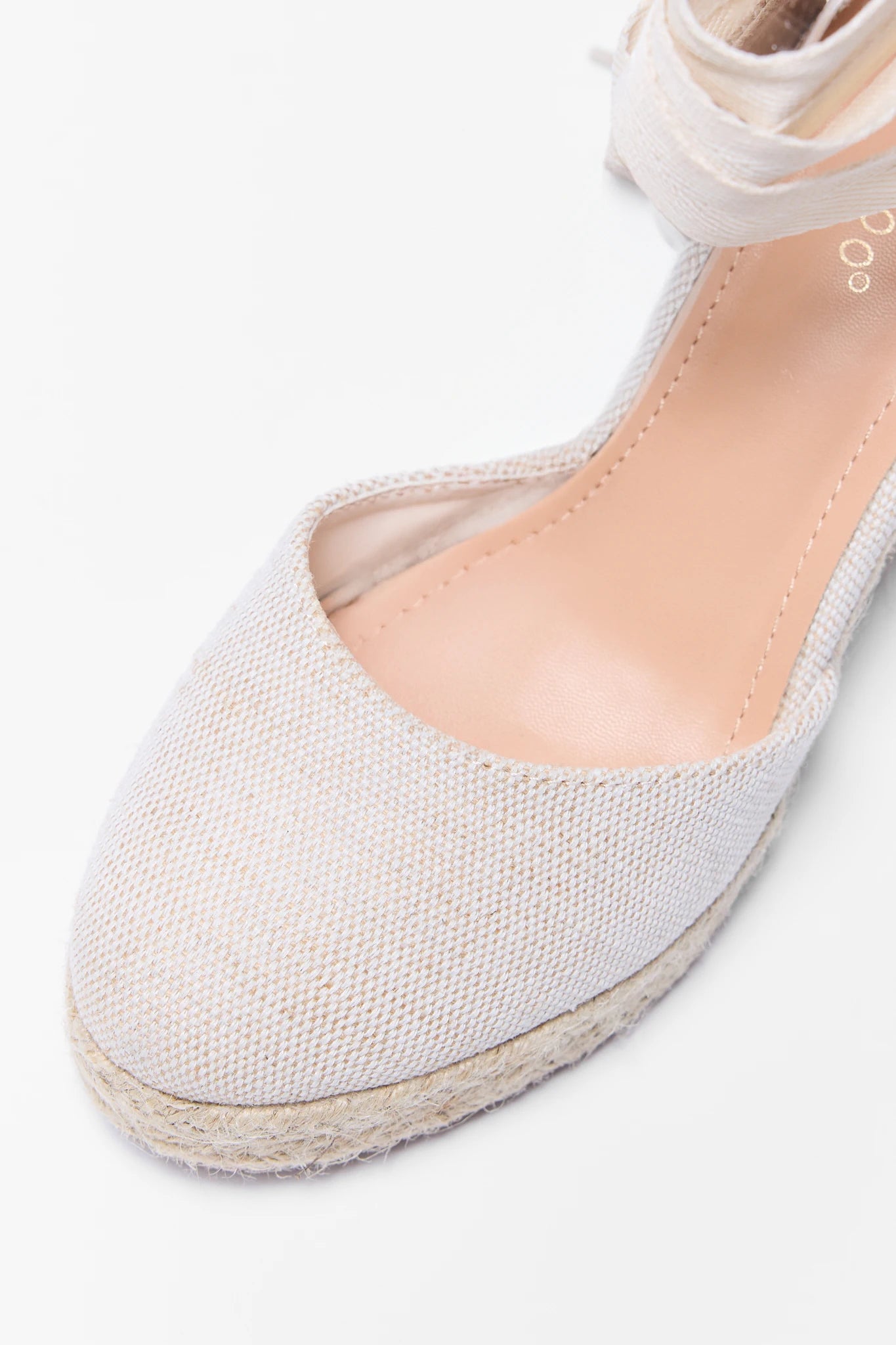 White flat shoe with jute sole on a white background