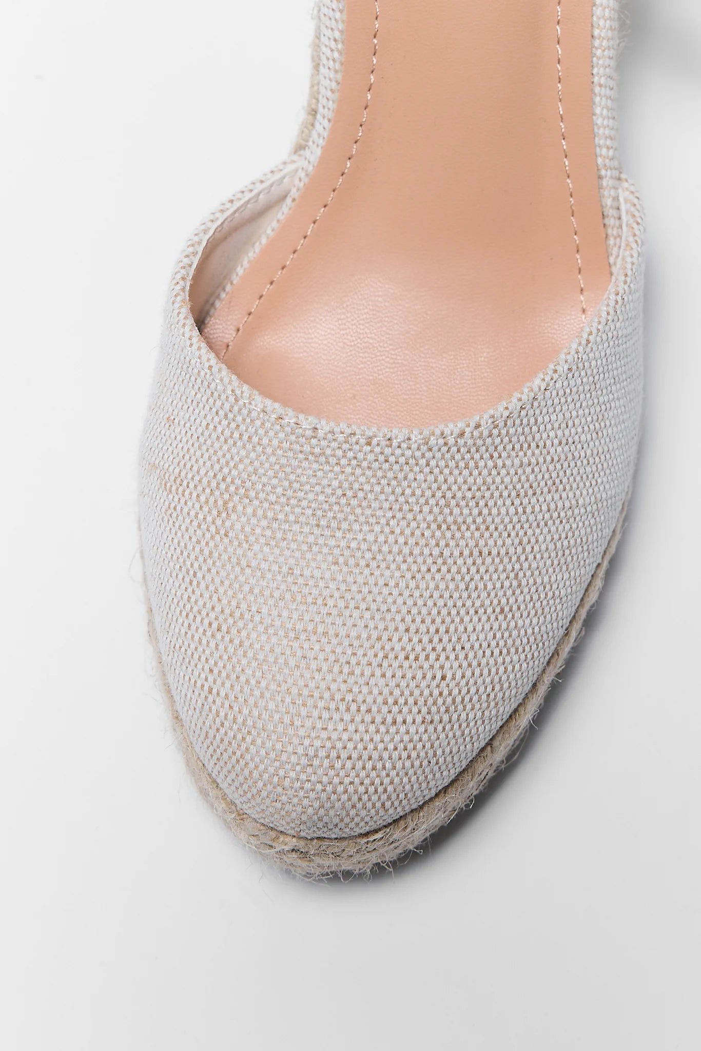 Close-up of a gray espadrille shoe on a light gray background