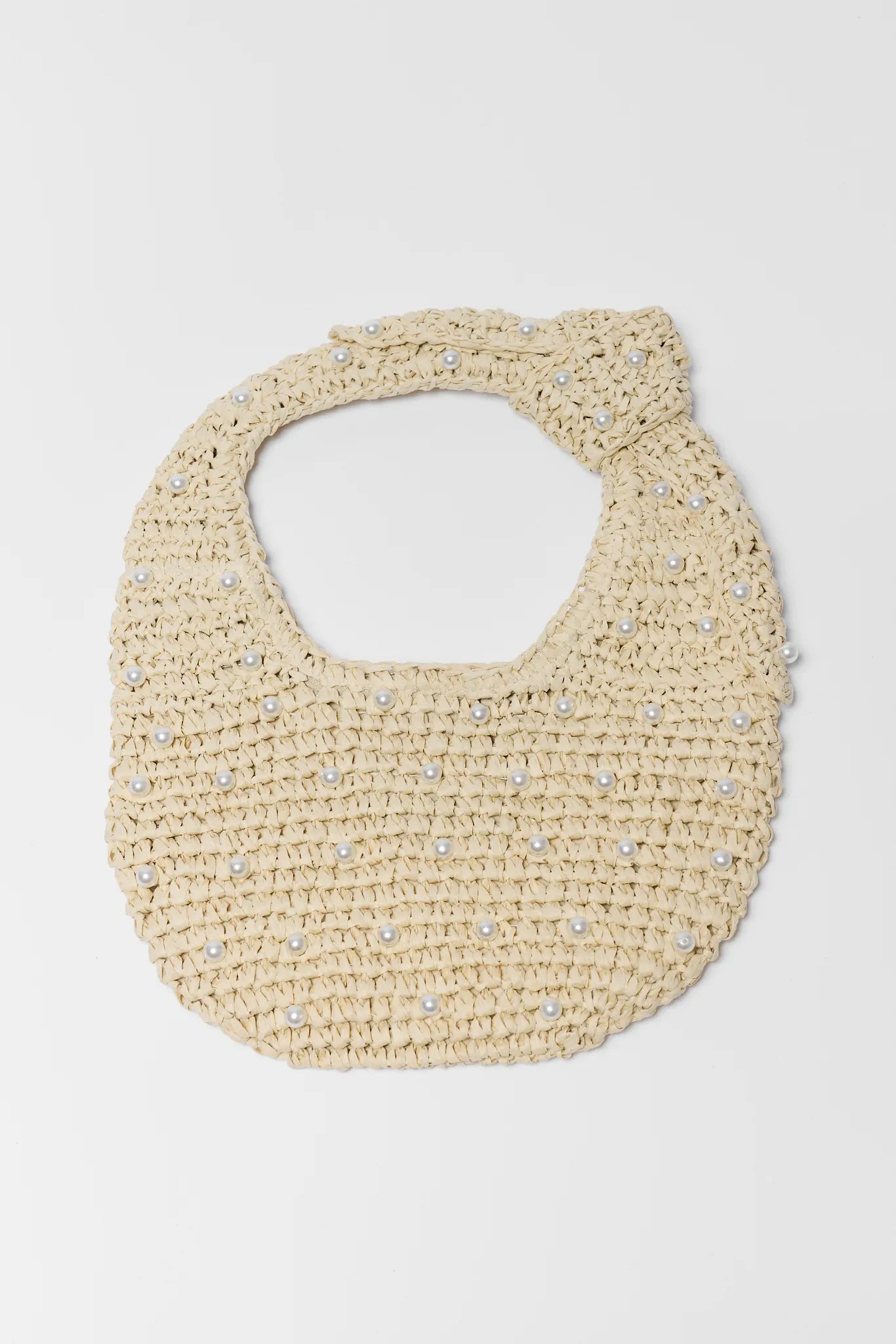 Beige woven bag with pearl embellishments on a white background