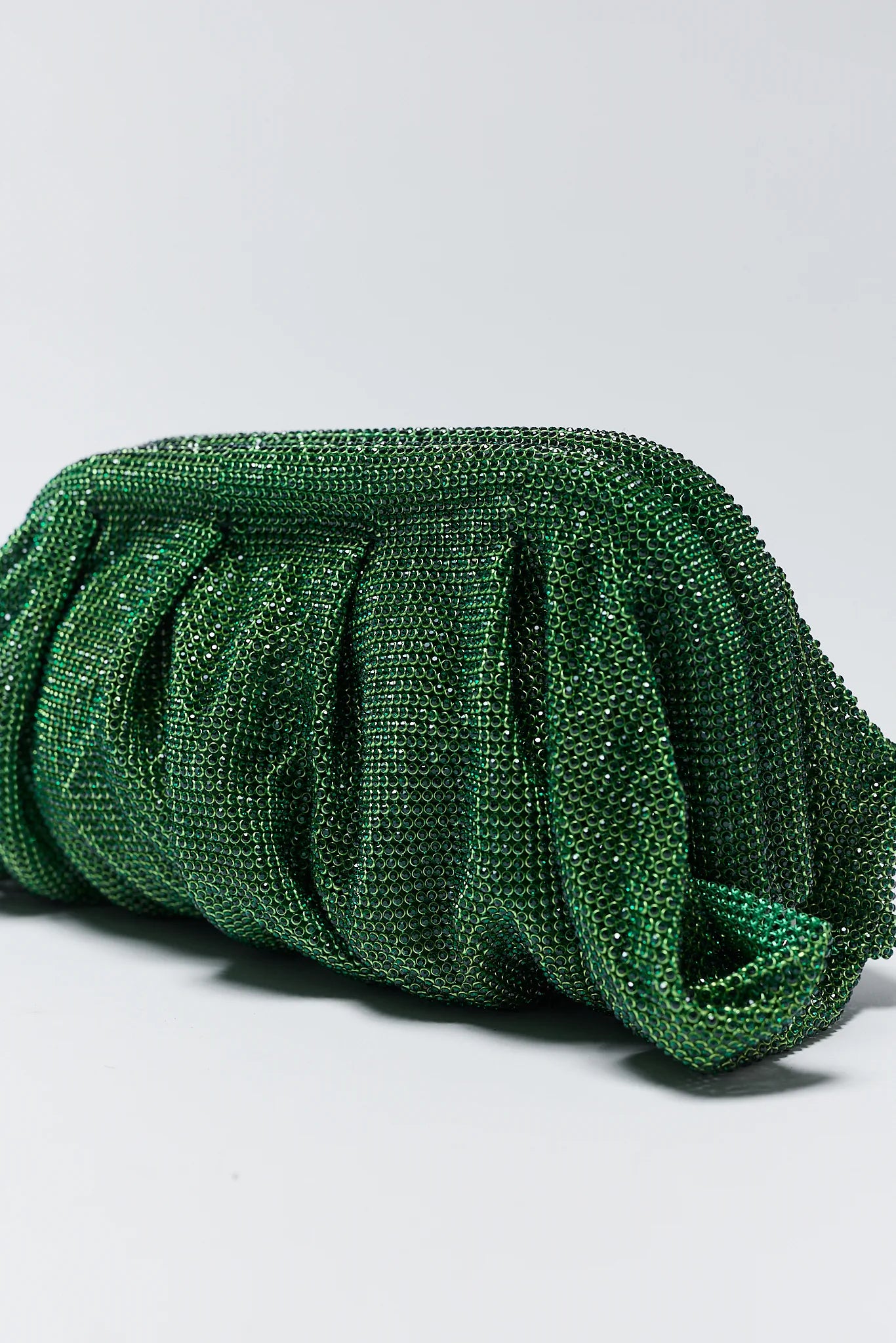 Green beaded clutch bag on a light gray background