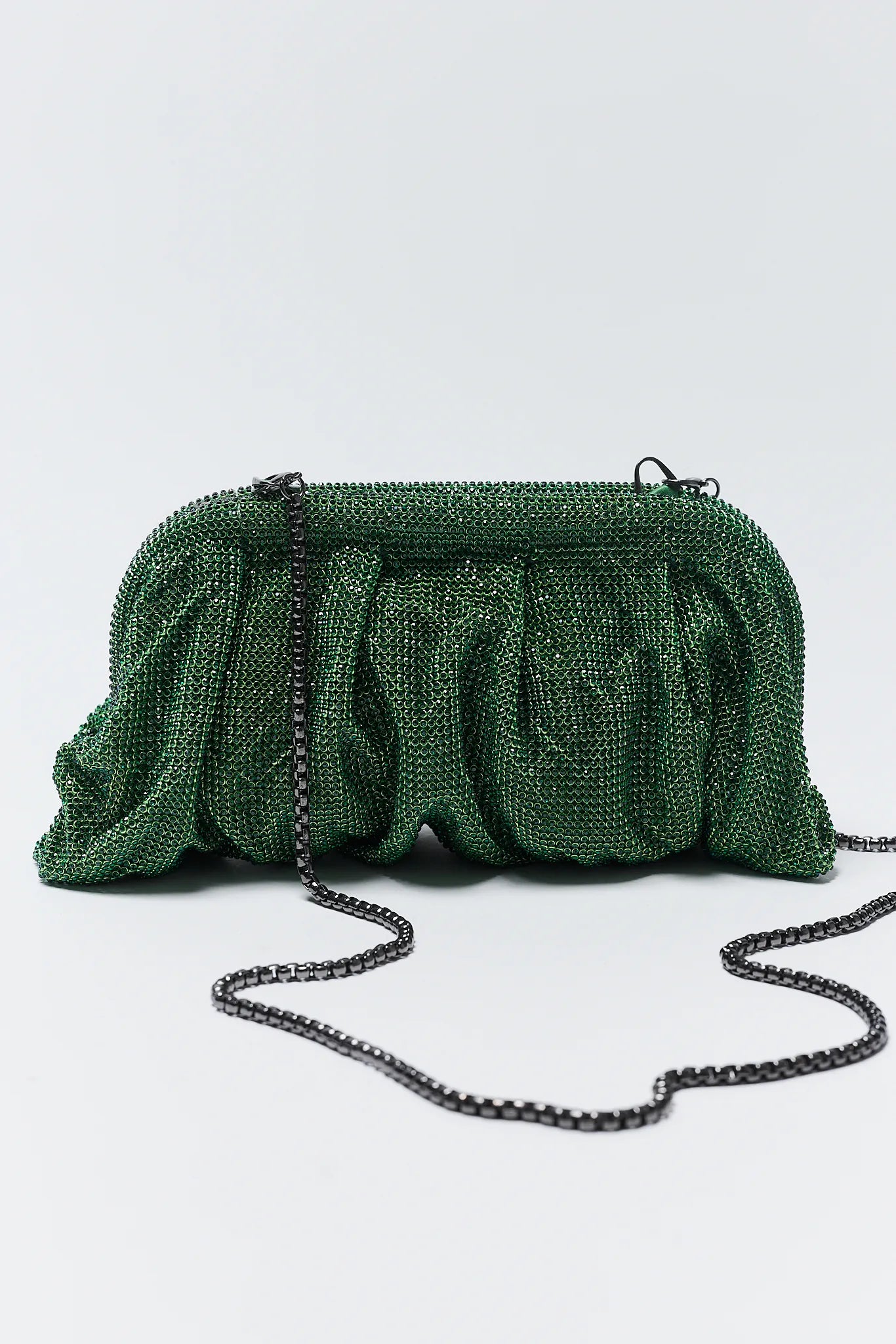 Green beaded clutch bag with a chain strap on a white background