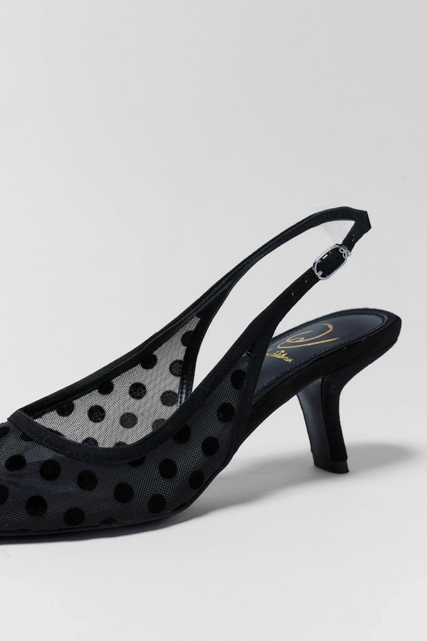 Black polka dot sandal on a light gray background