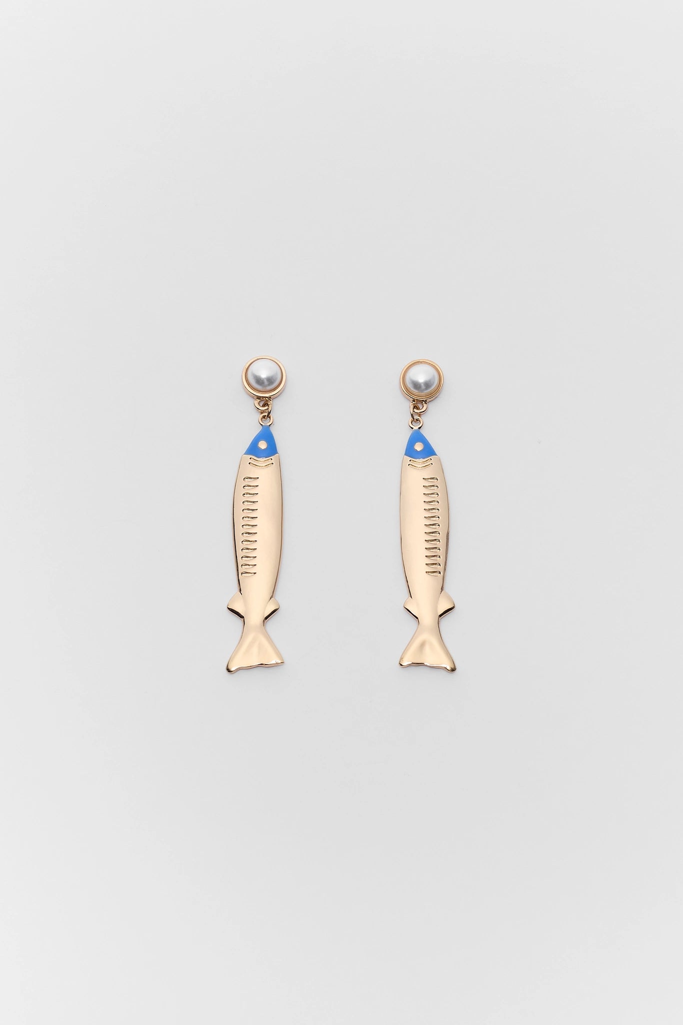 Fish-shaped earrings with pearl accents on a light gray background