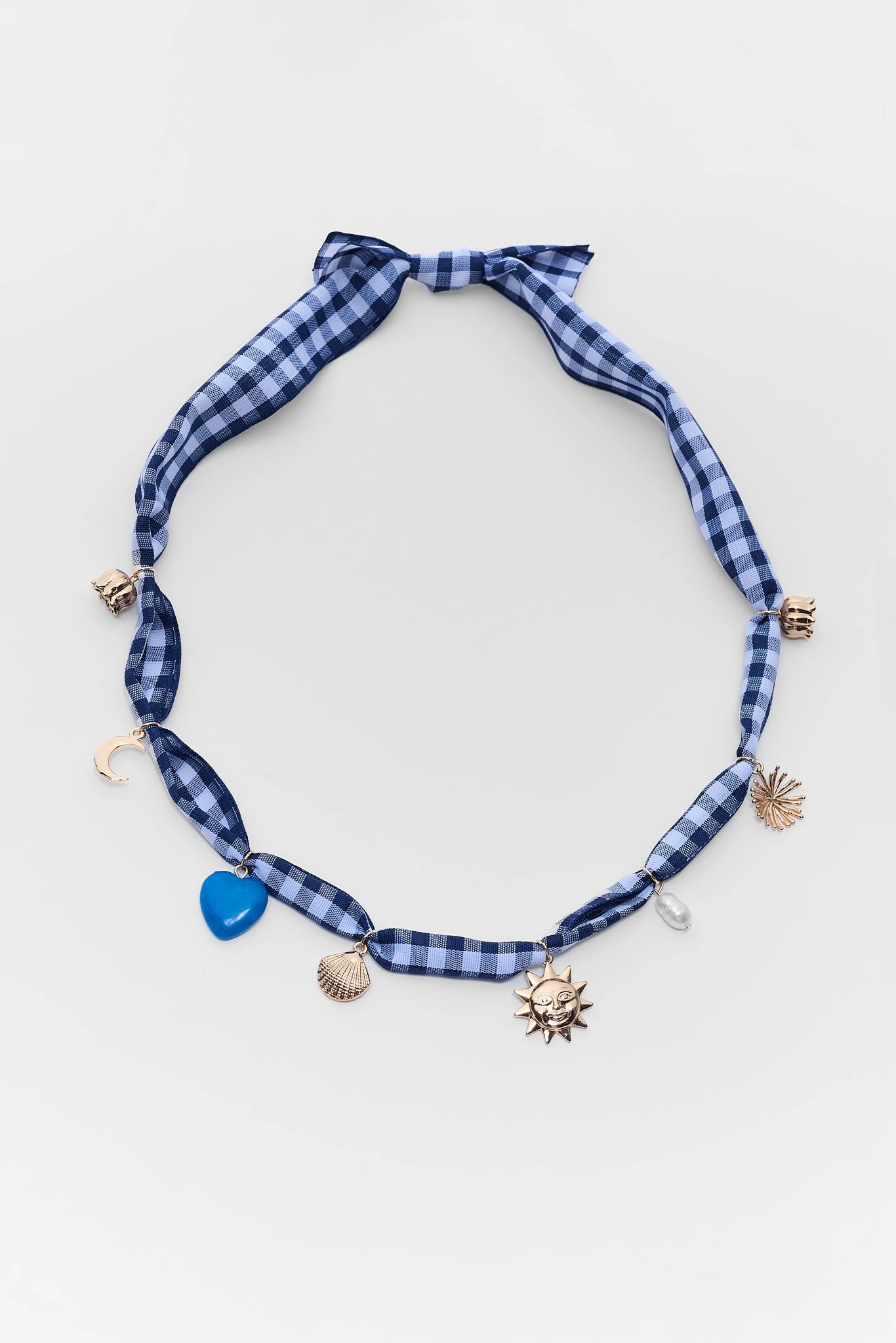 Blue plaid ribbon choker necklace with shell and starfish charms on a light gray background