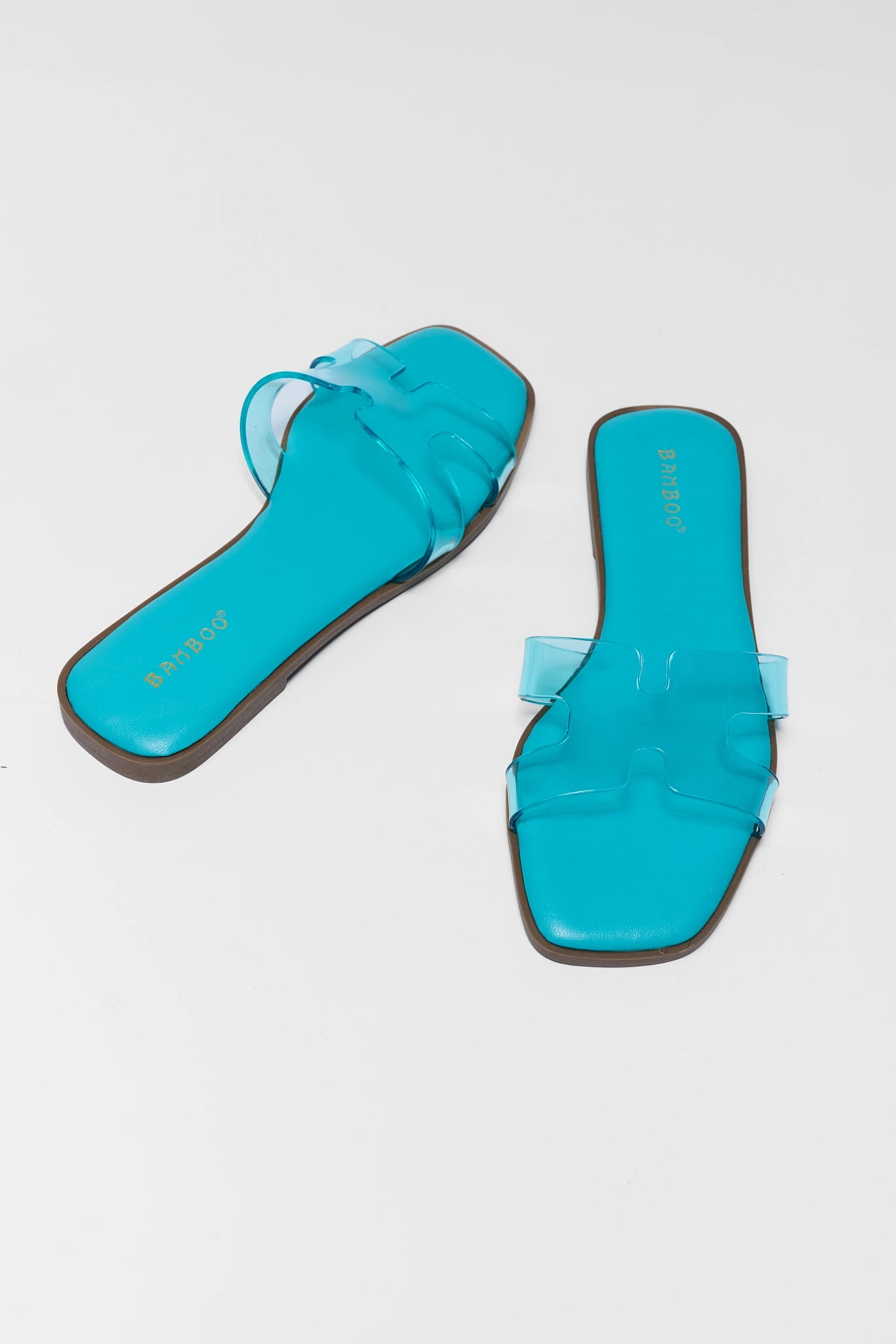 Pair of turquoise sandals on a light gray background