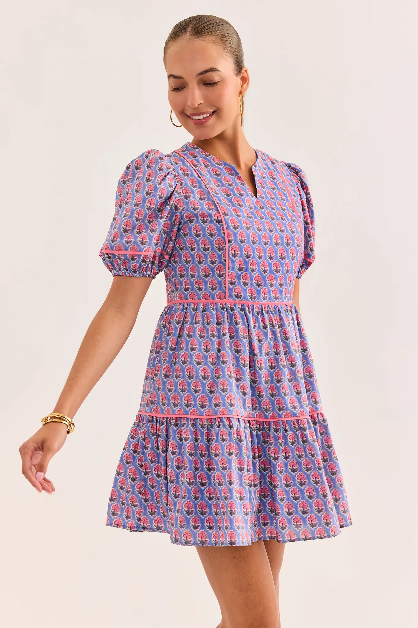Woman wearing a blue and pink patterned dress on a plain background lifestyle
