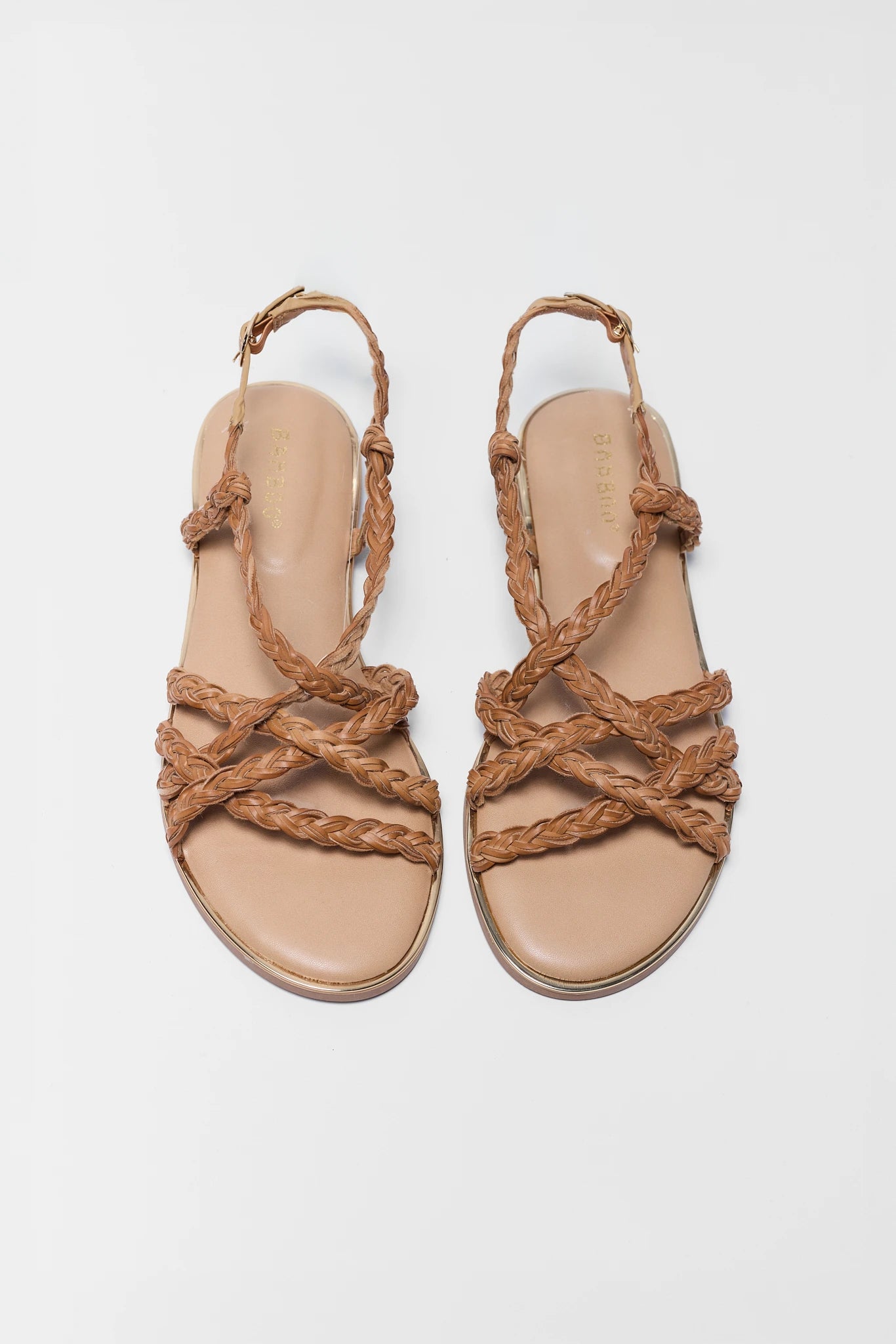 Pair of two beige sandals with braided straps on a light gray background