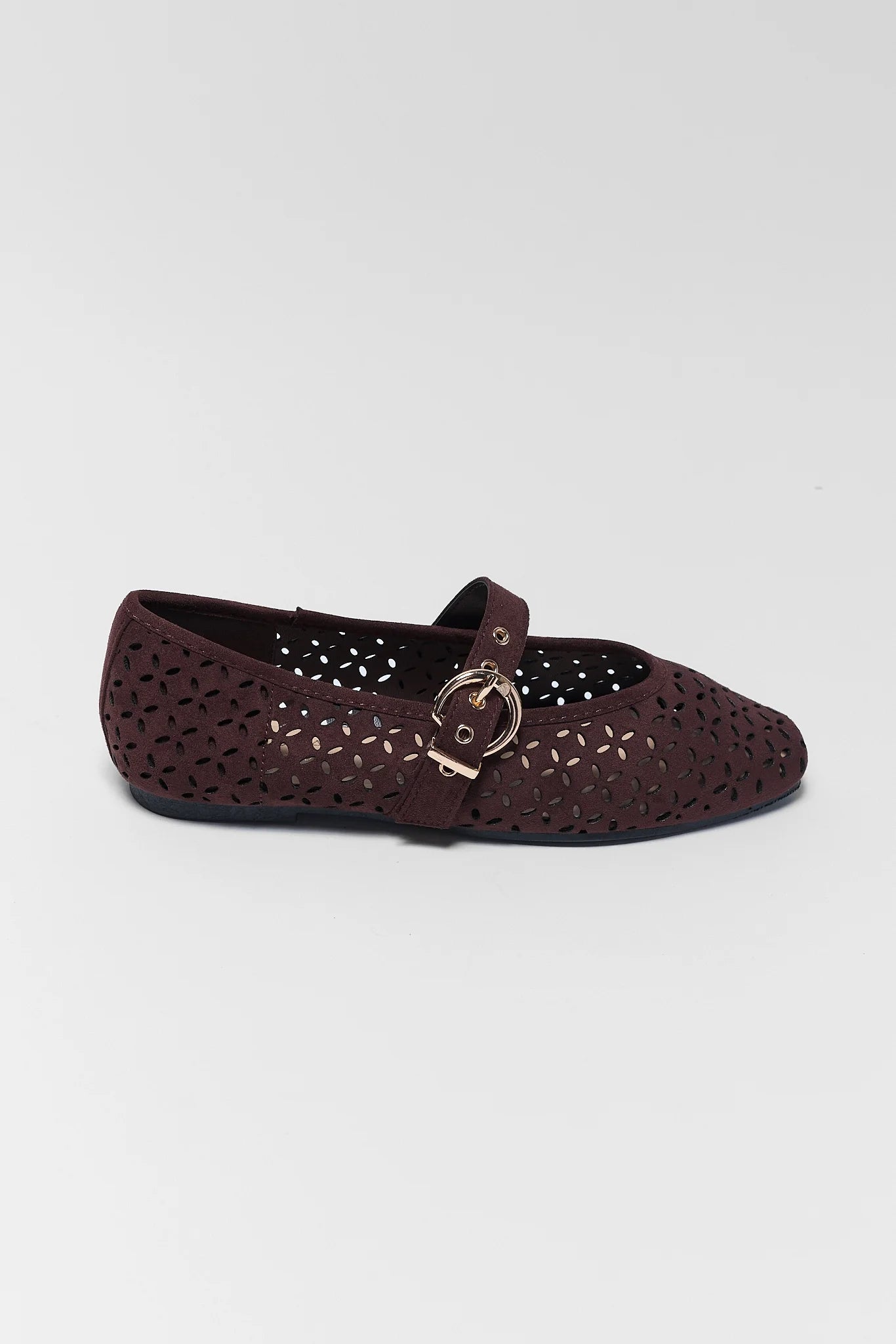A single dark brown flat shoe with a laser-cut perforated pattern and a decorative gold-tone buckle strap, shown against a plain light gray background.