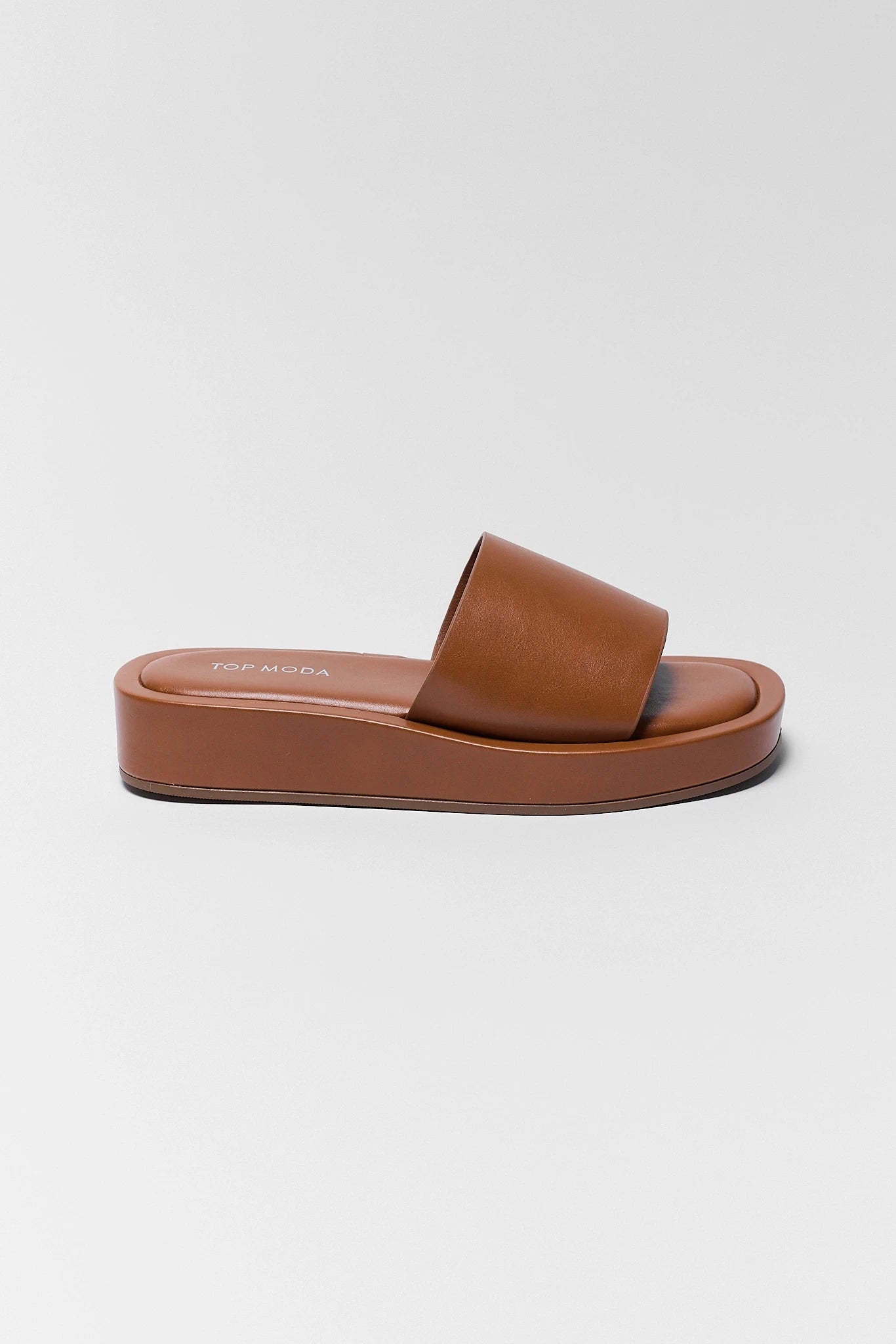 one Brown sandal with a textured strap on a white background