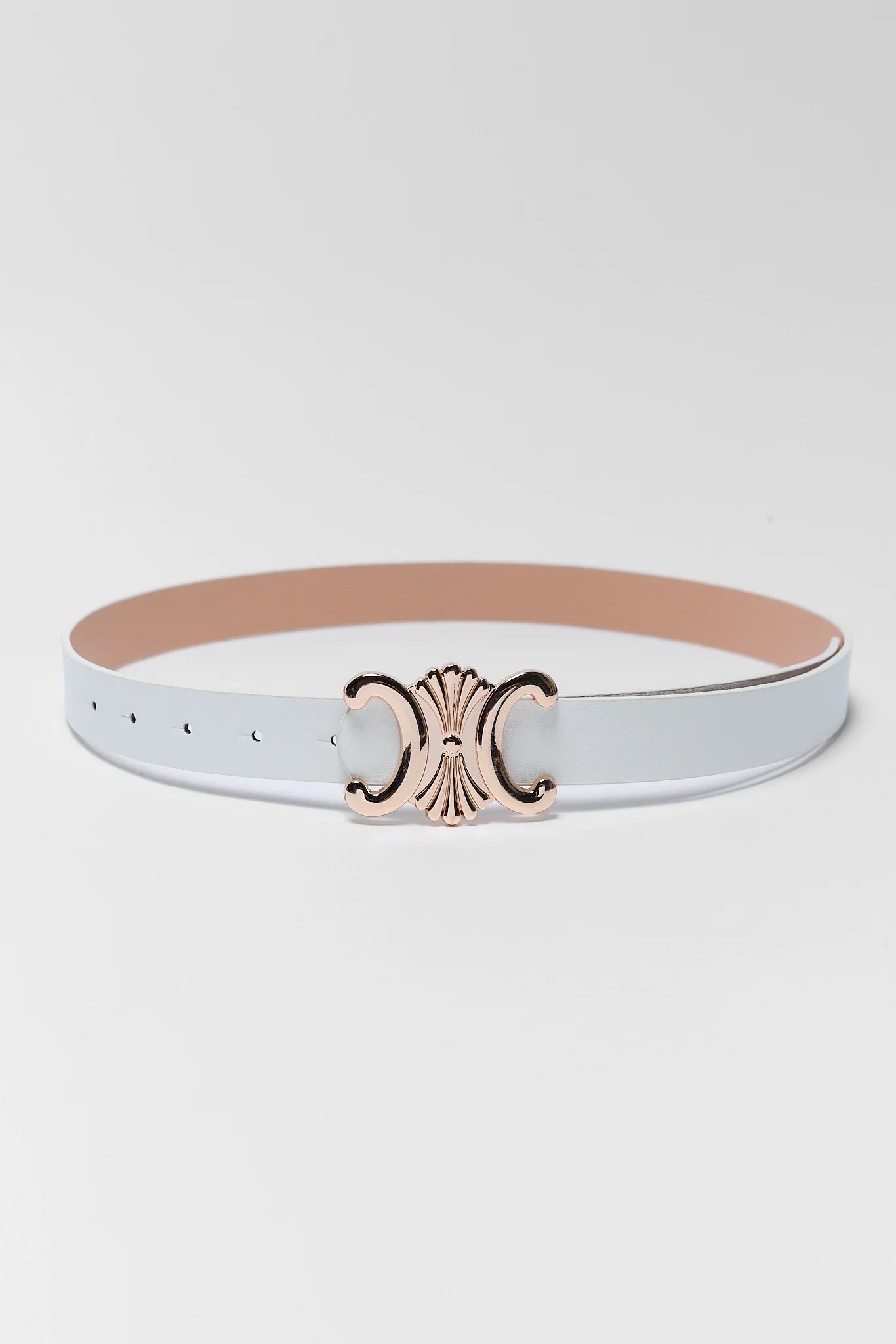 A slim white faux leather belt with a rose gold Celine Triomphe logo buckle, shown against a light gray studio background.