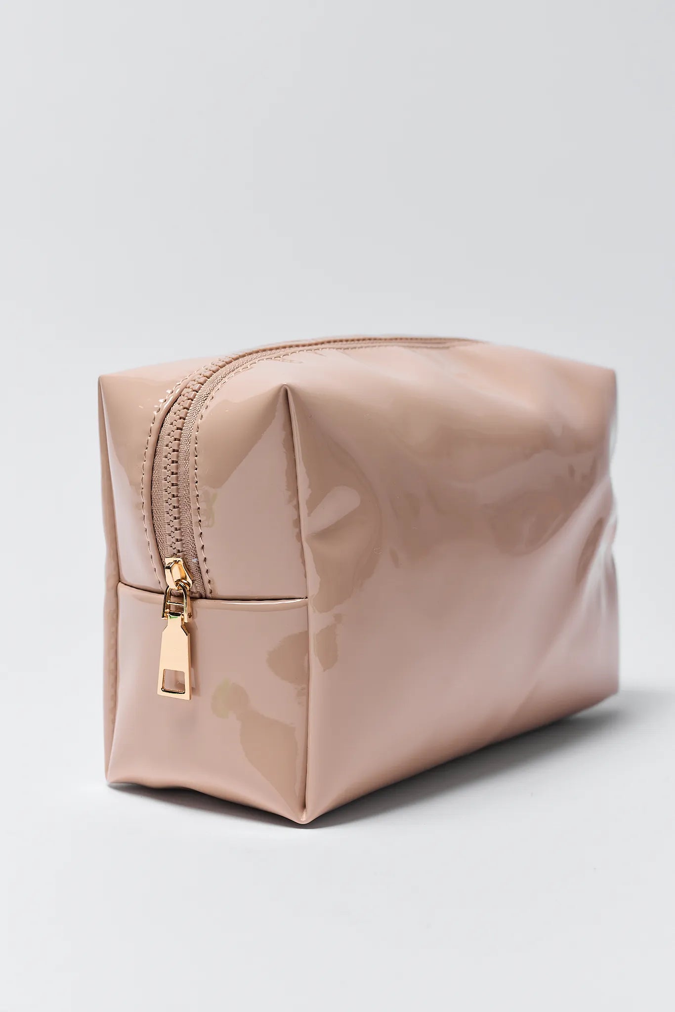 Pink cosmetic bag with gold zipper on a light gray background