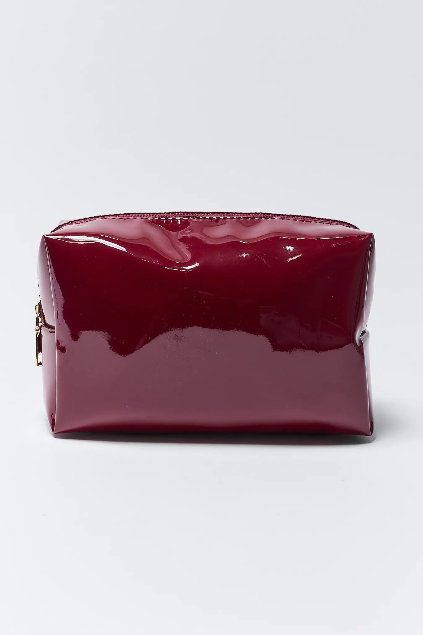 Shiny red cosmetic bag on a light gray background