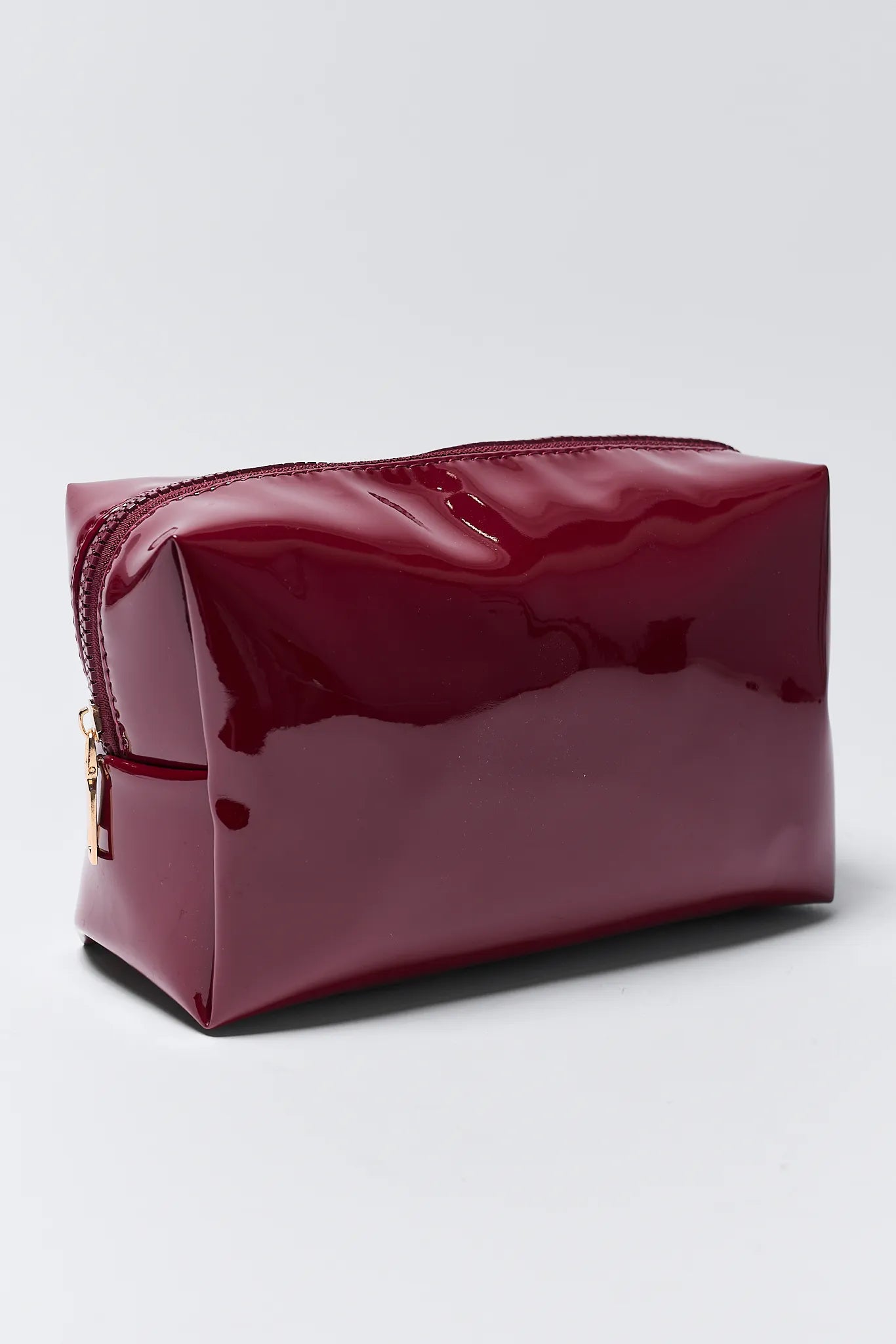 Shiny red cosmetic bag on a light gray background