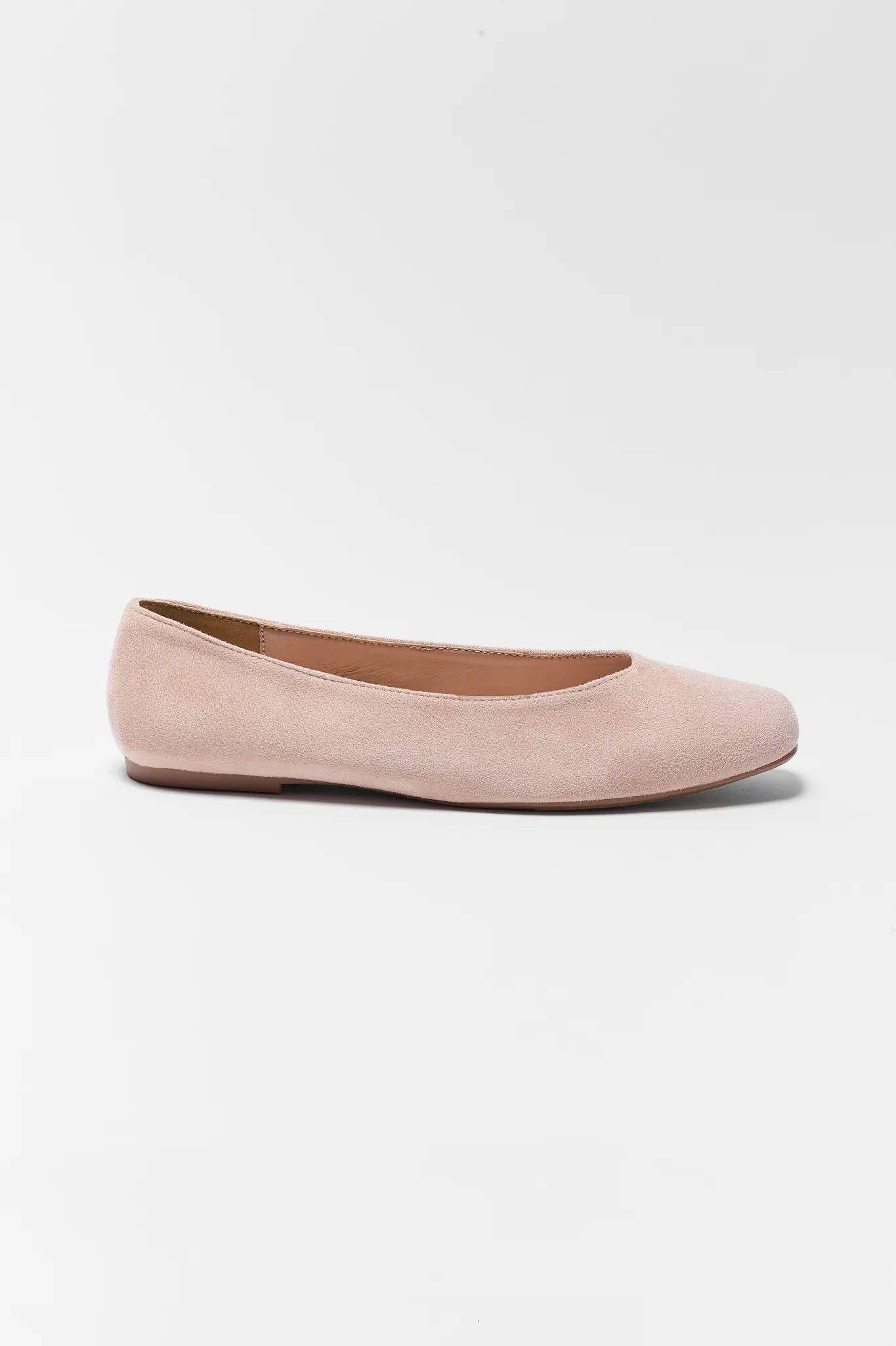 Pink suede flat shoe on a light gray background