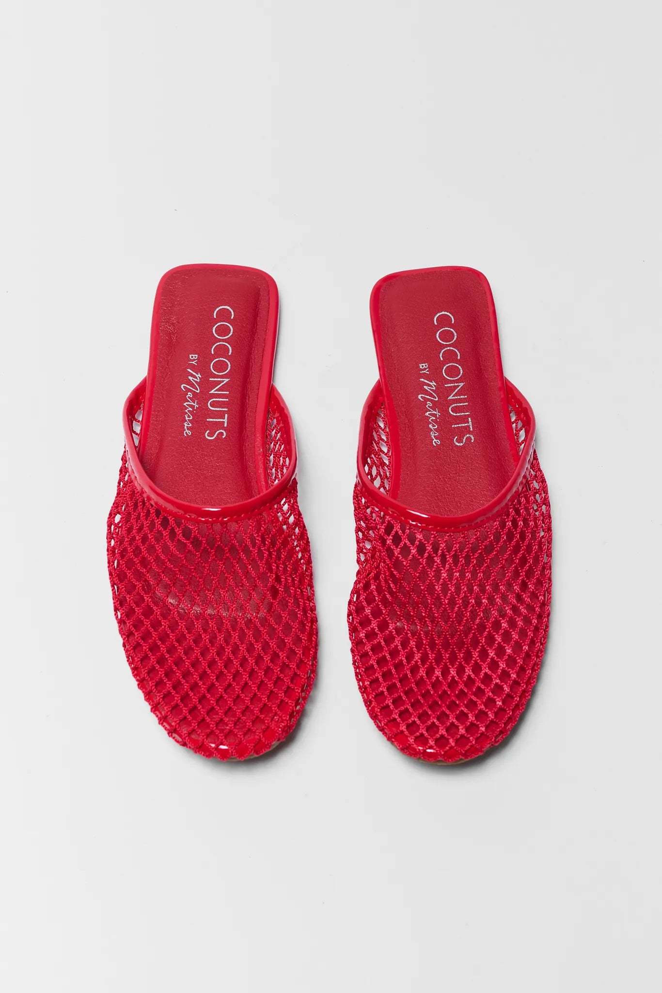 Red mesh sandals with 'Coconuts' branding on a light gray background