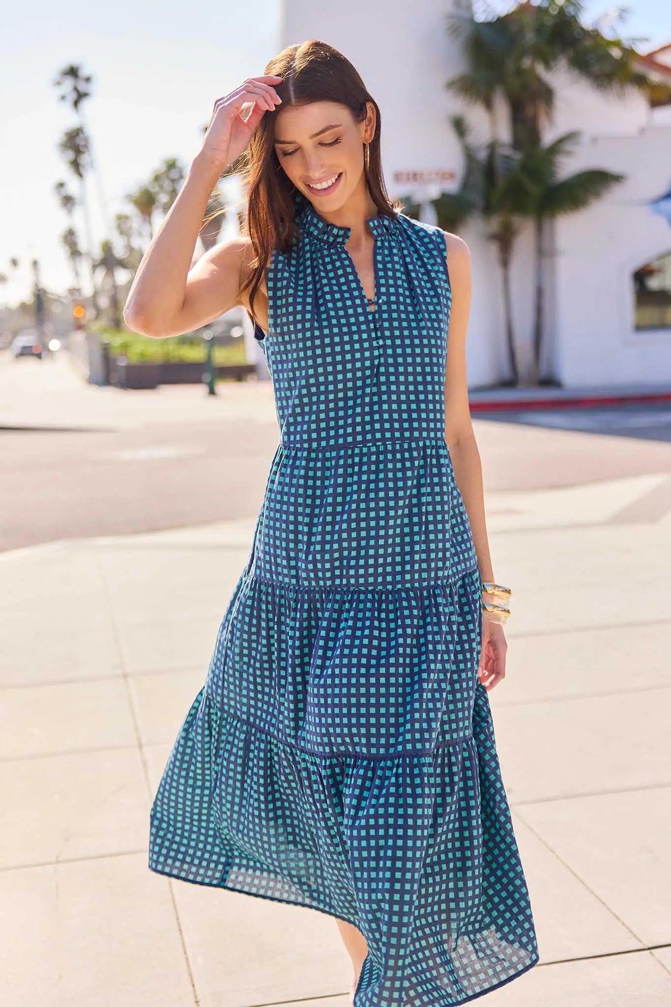 Woman wearing a blue patterned dress on a city street.
