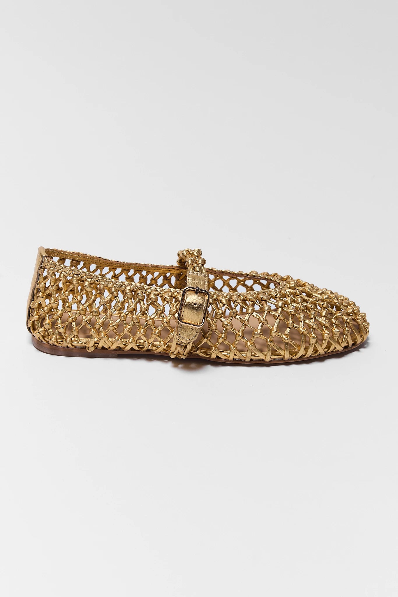 one Gold woven flat shoe with a strap on a white background