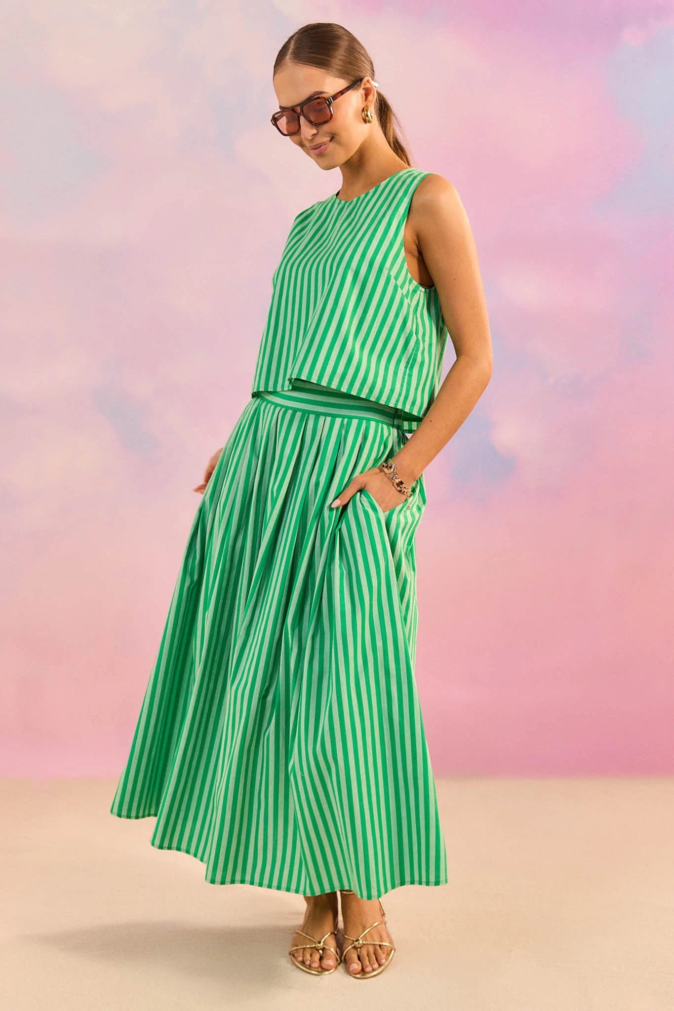 Woman wearing a green and white striped dress against a colorful background