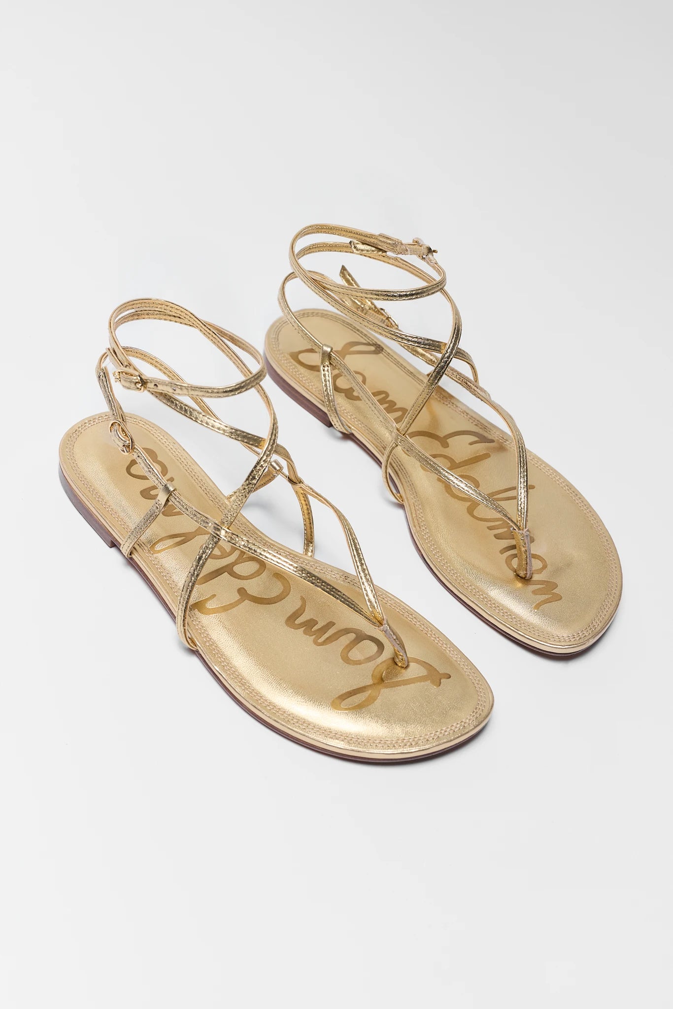Pair of two gold sandals on a white background