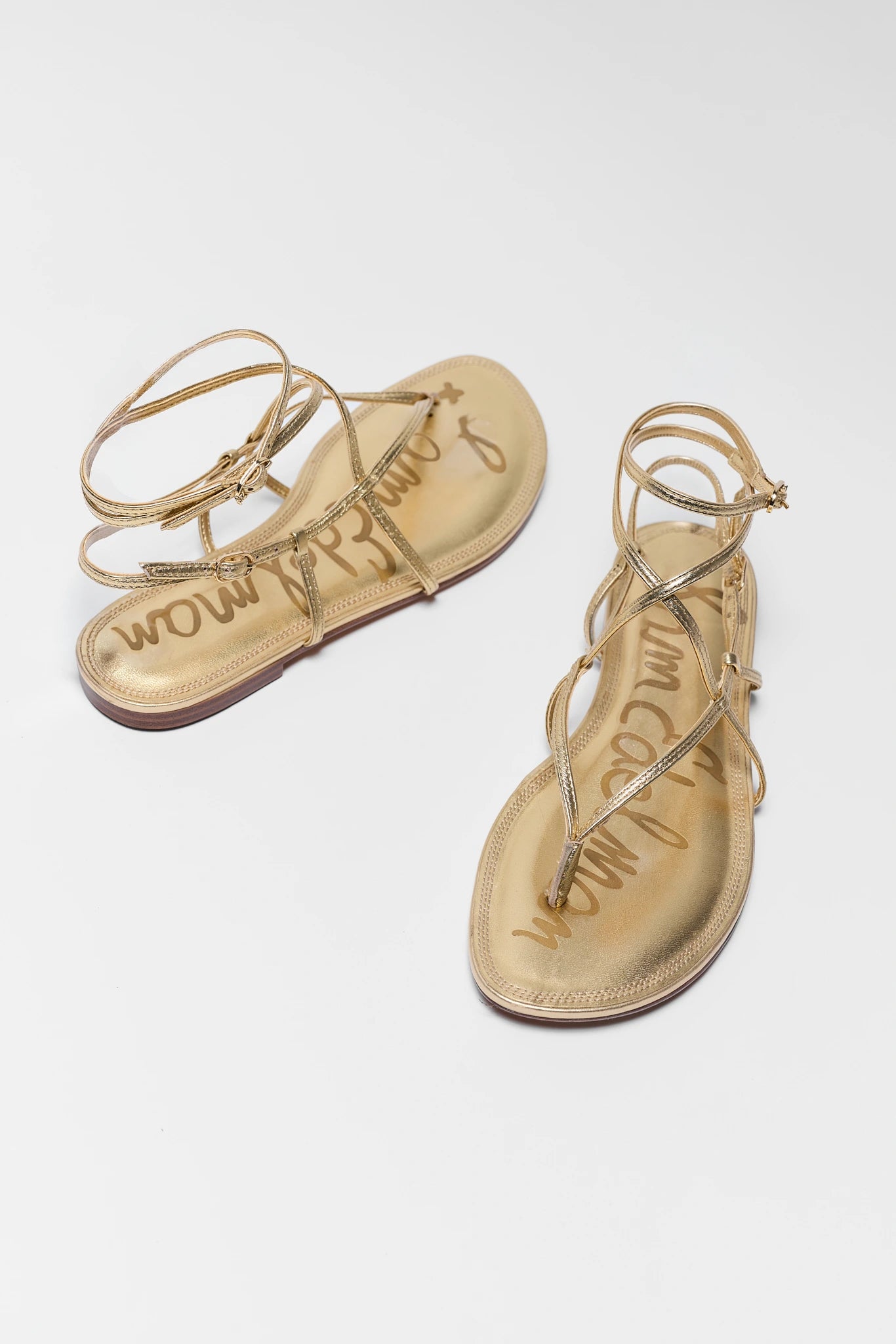 Pair of gold sandals with 'Sam Edelman' branding on a white background two