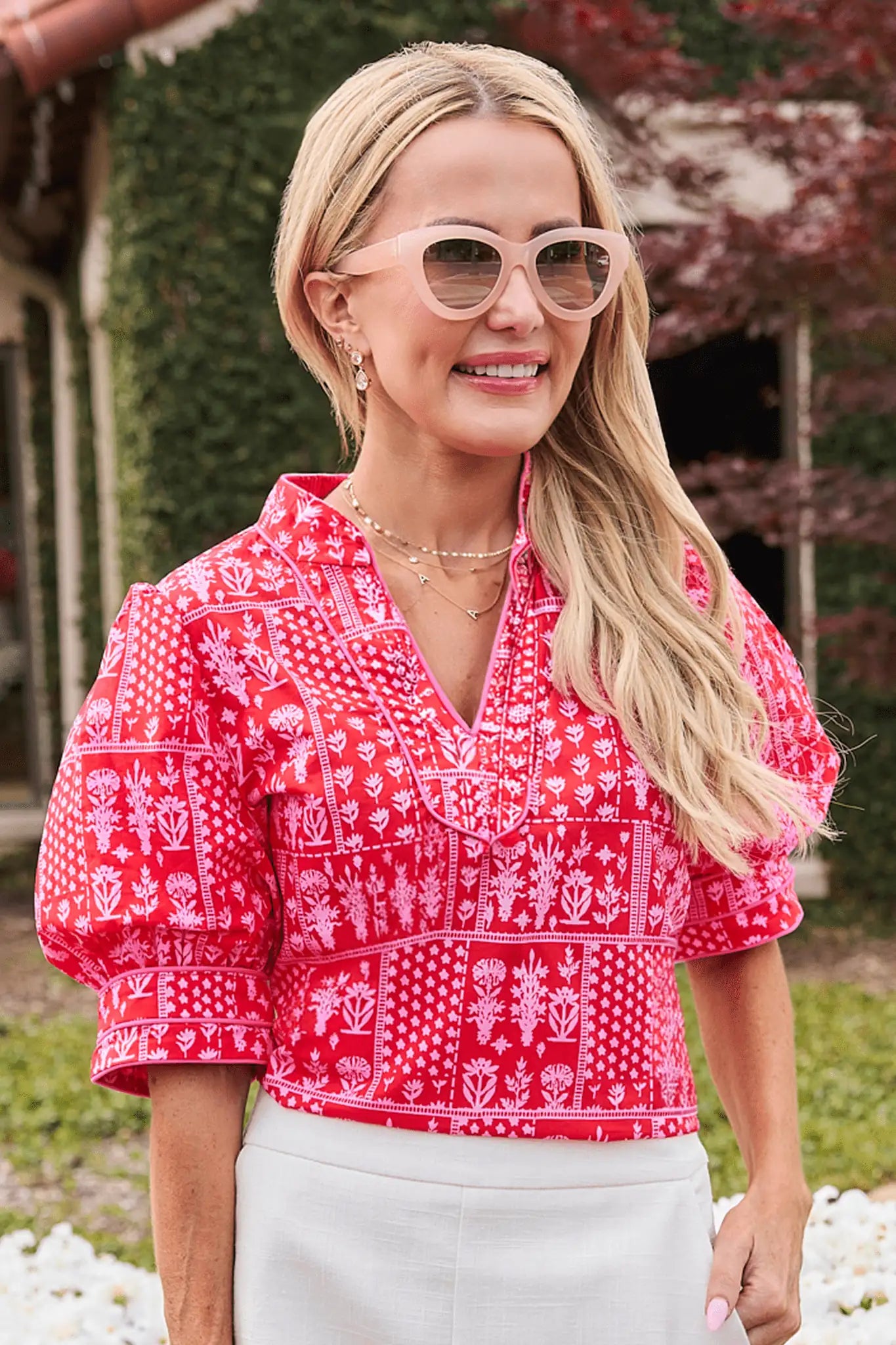 Woman wearing a red patterned blouse and sunglasses outdoors. lifestyle