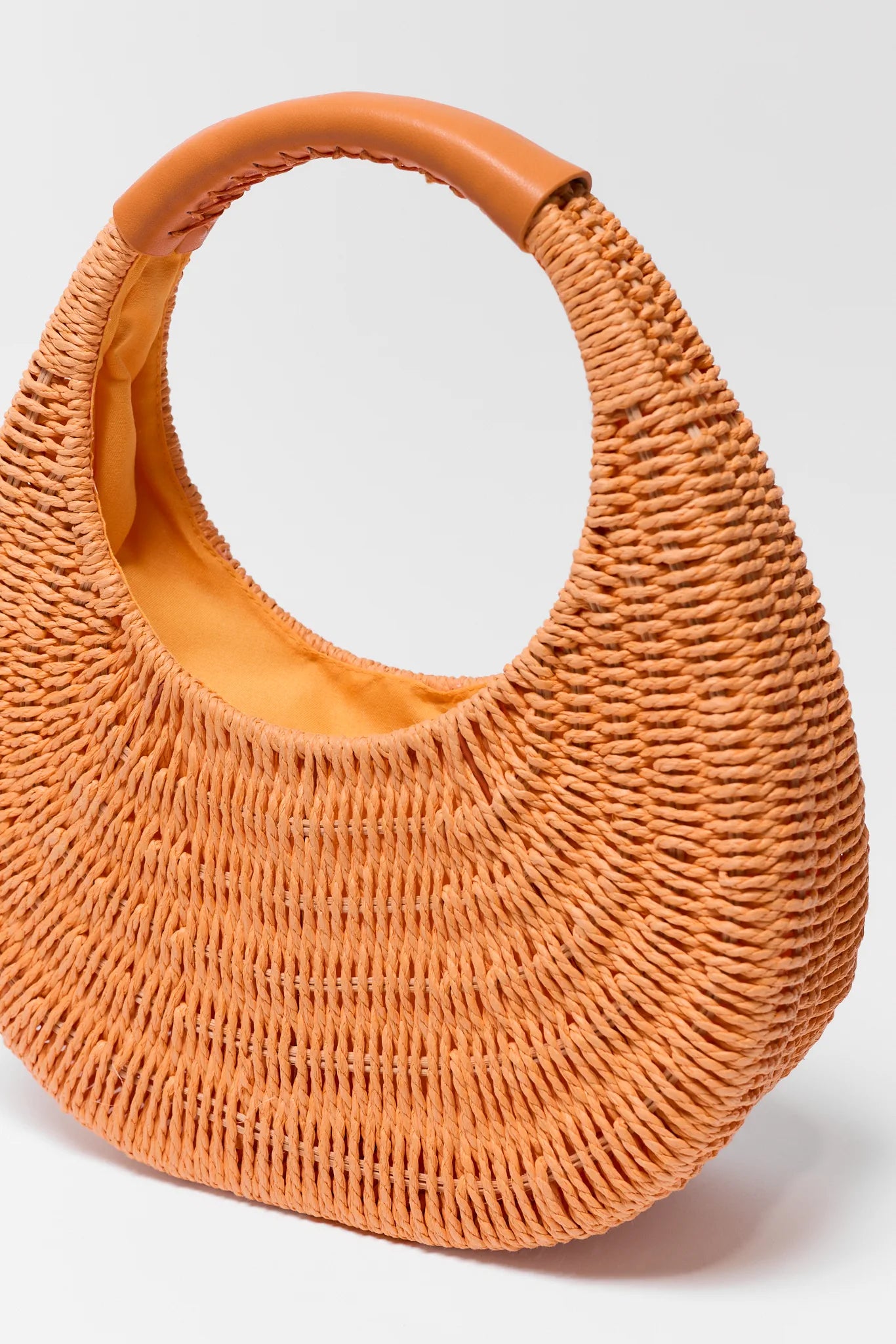 Orange woven handbag on a white background