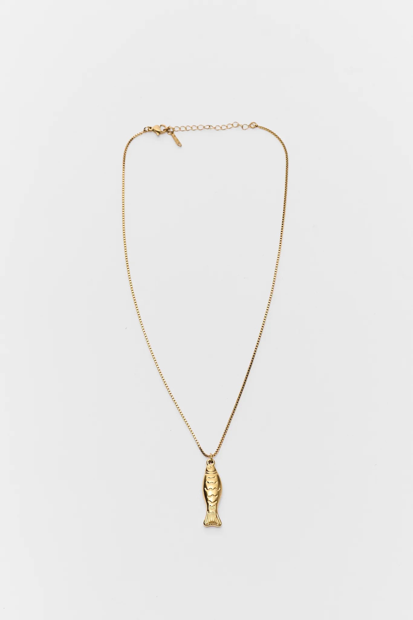Gold necklace with a fish pendant on a white background