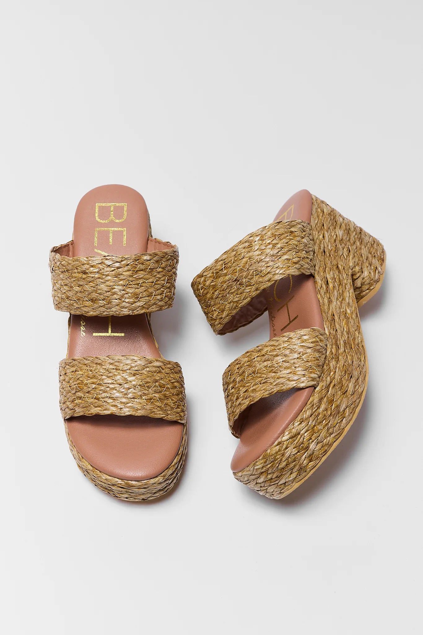 Pair of woven sandals on a light gray background