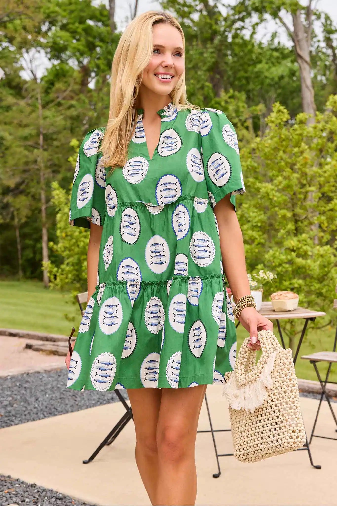 Woman wearing a green dress with white sardine patterns outdoors