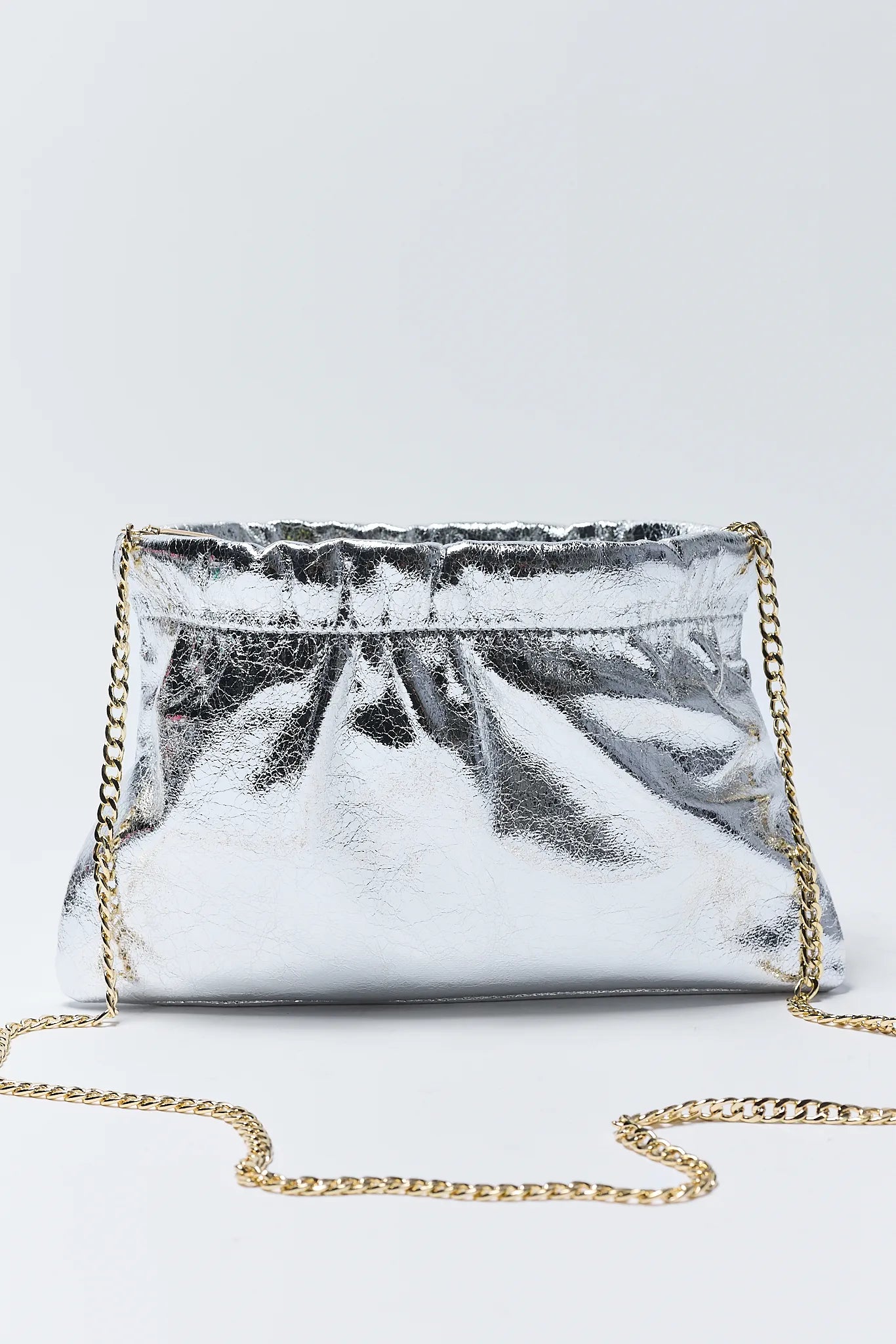 Silver clutch bag with gold chain on a white background