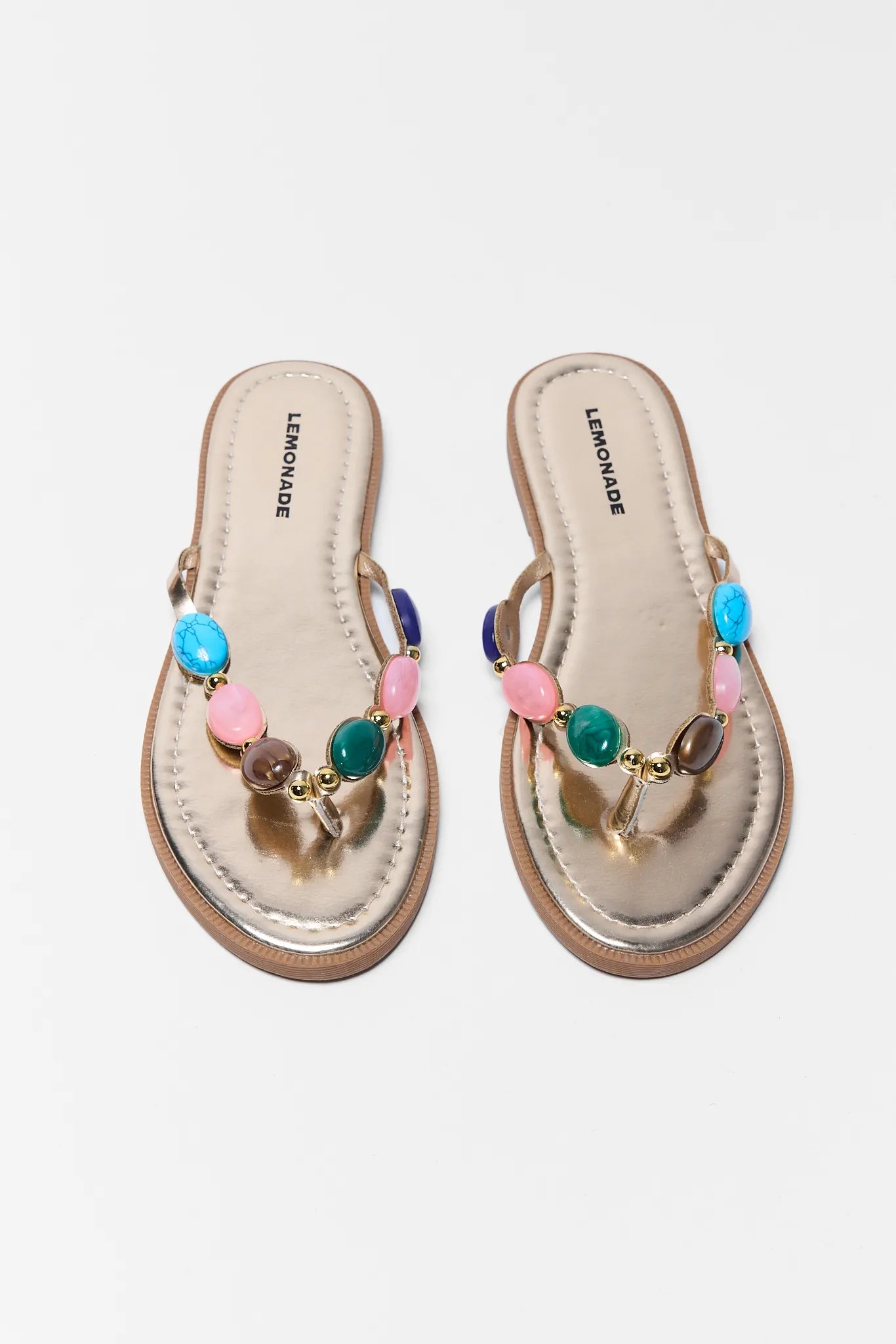 Pair of sandals with colorful beads on a light gray background