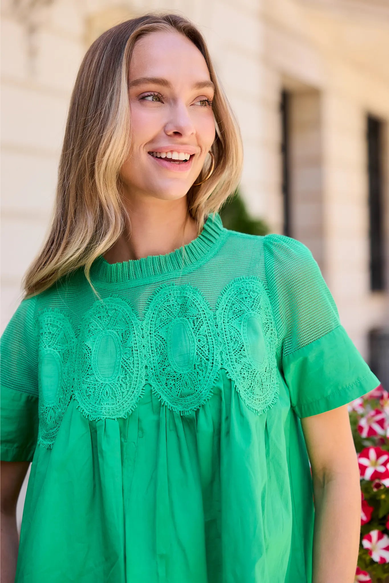 Woman outdoors wearing a green blouse with a textured pattern close up