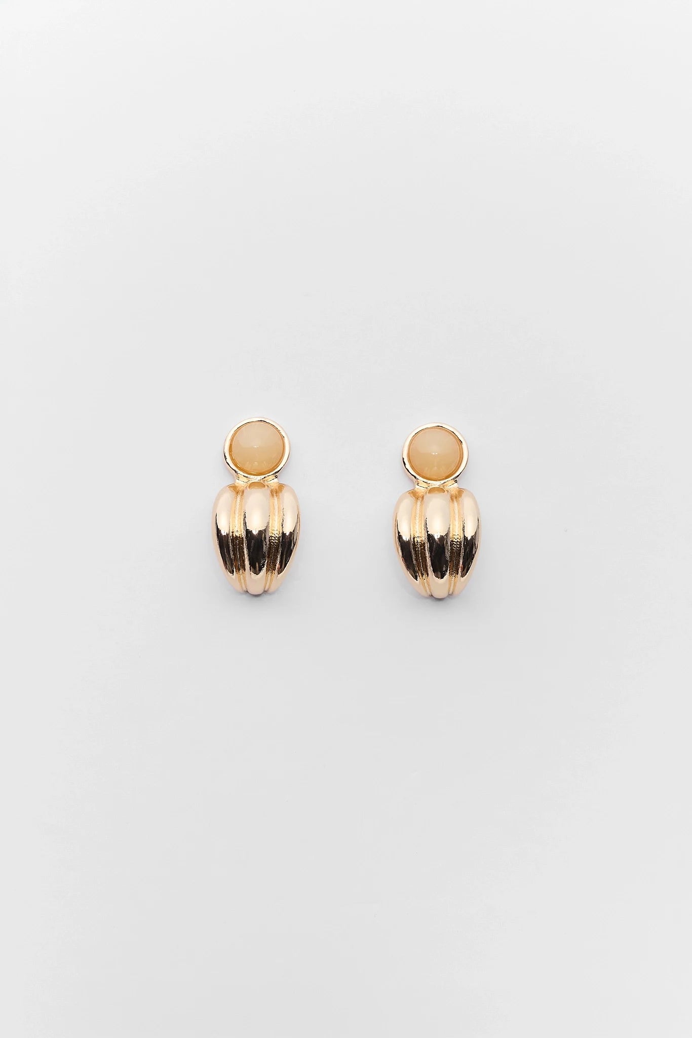 Pair of gold earrings on a light gray background