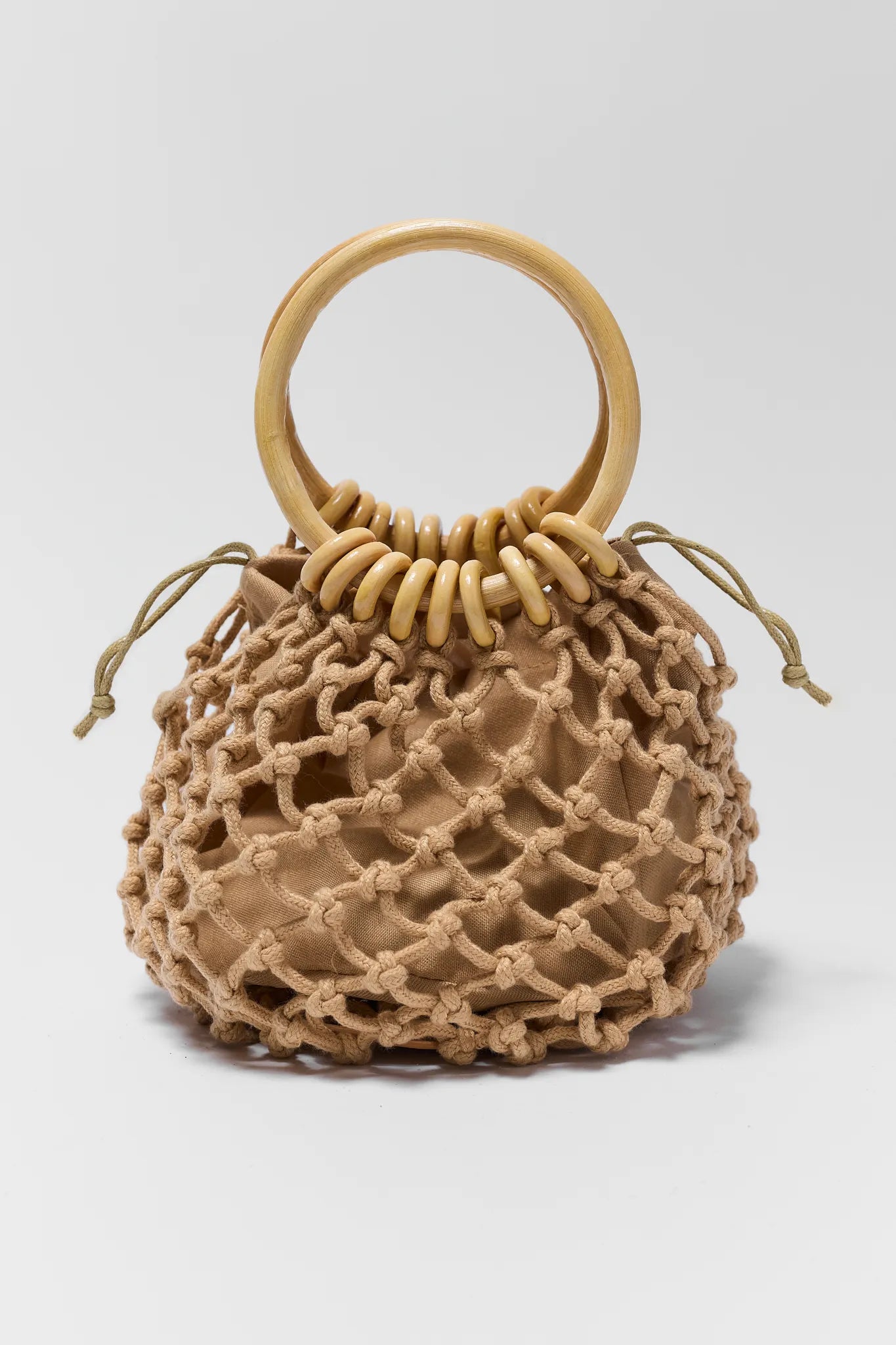 Beige woven handbag with wooden handle on a light gray background