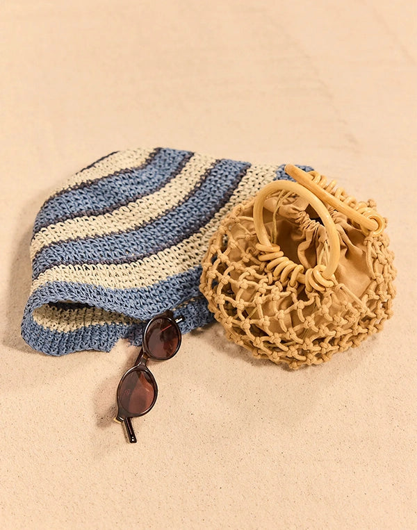 Blue and white striped bag, beige woven bag, and sunglasses on a beige background