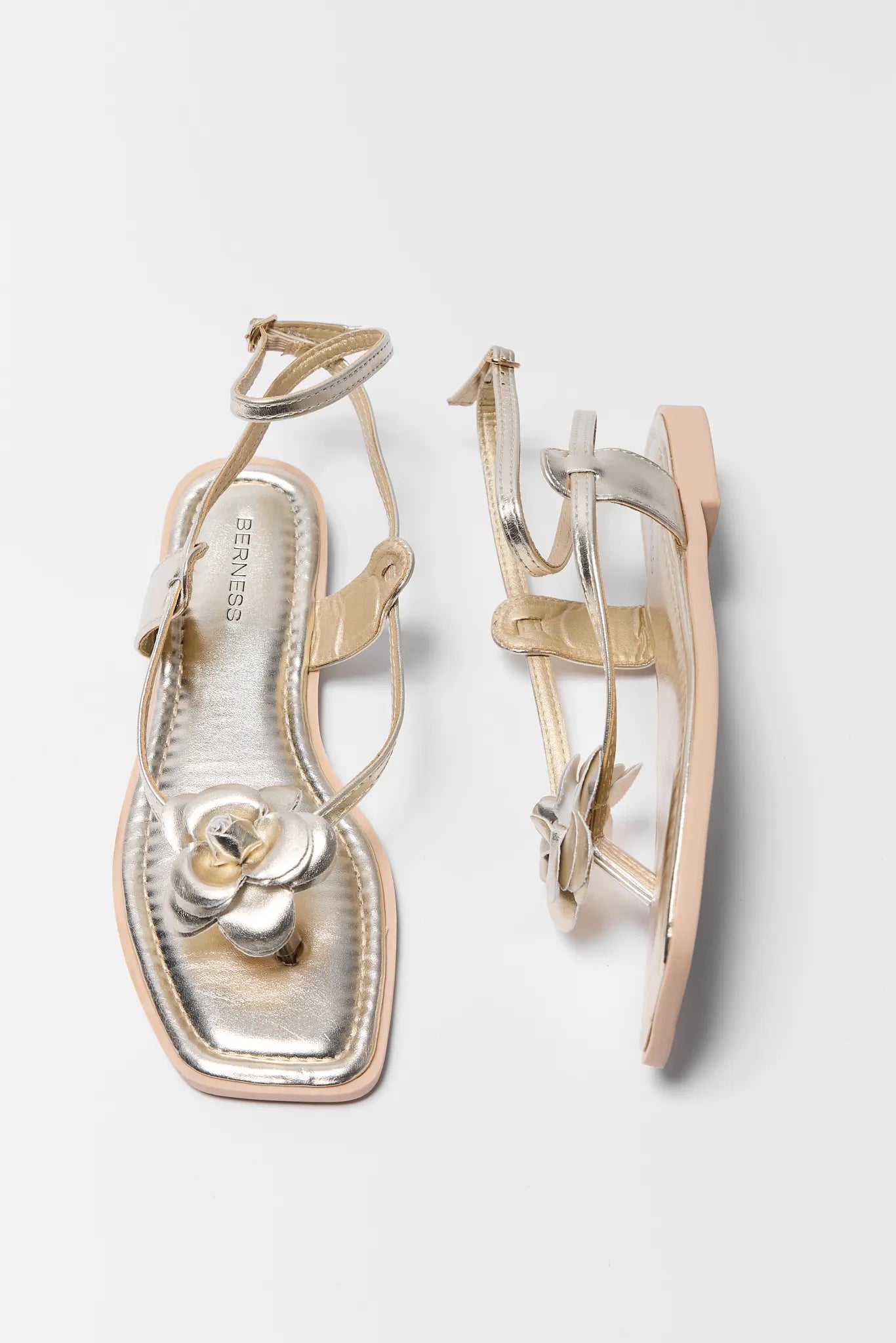 Harper Gold Strappy Flower Sandals with a decorative flower on a light gray background