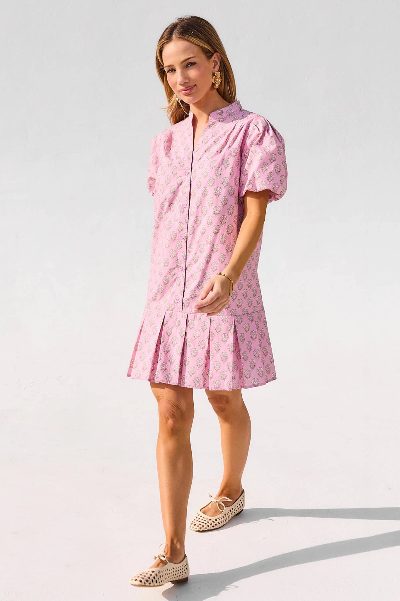 Woman wearing a pink dress with a white background