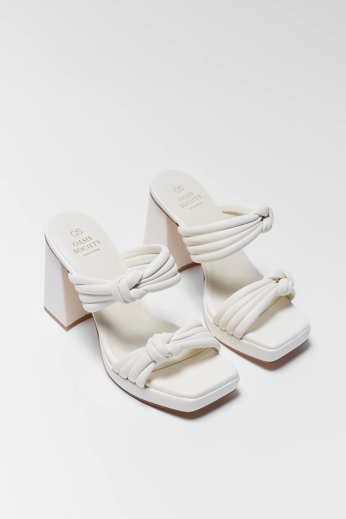 White sandals with braided straps on a white background