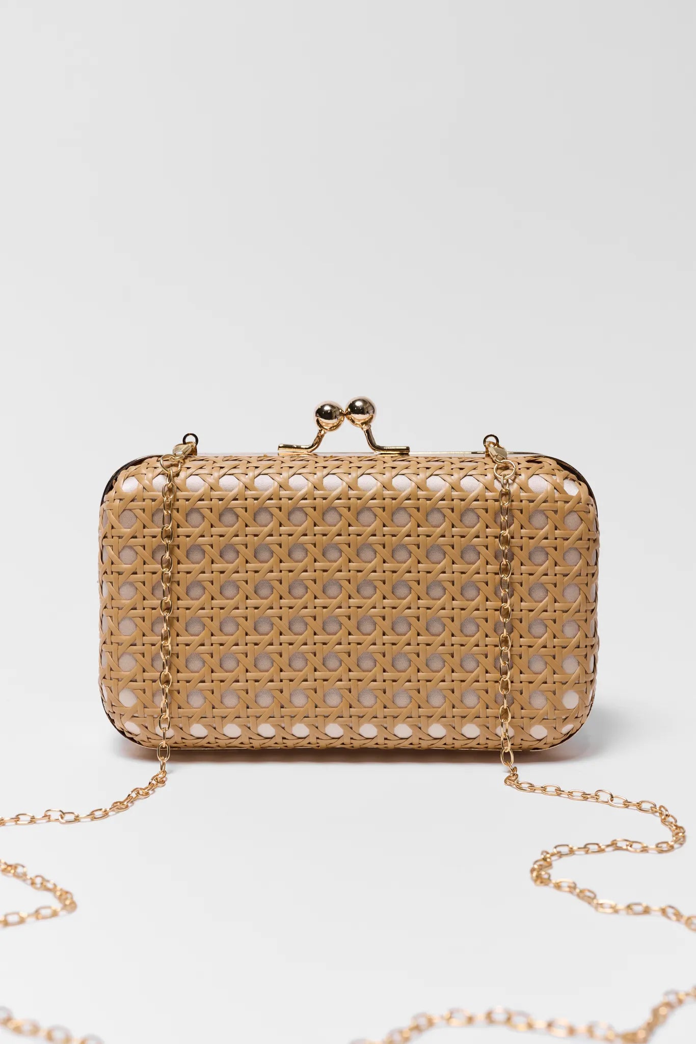 Tan clutch bag with a chain strap on a light gray background