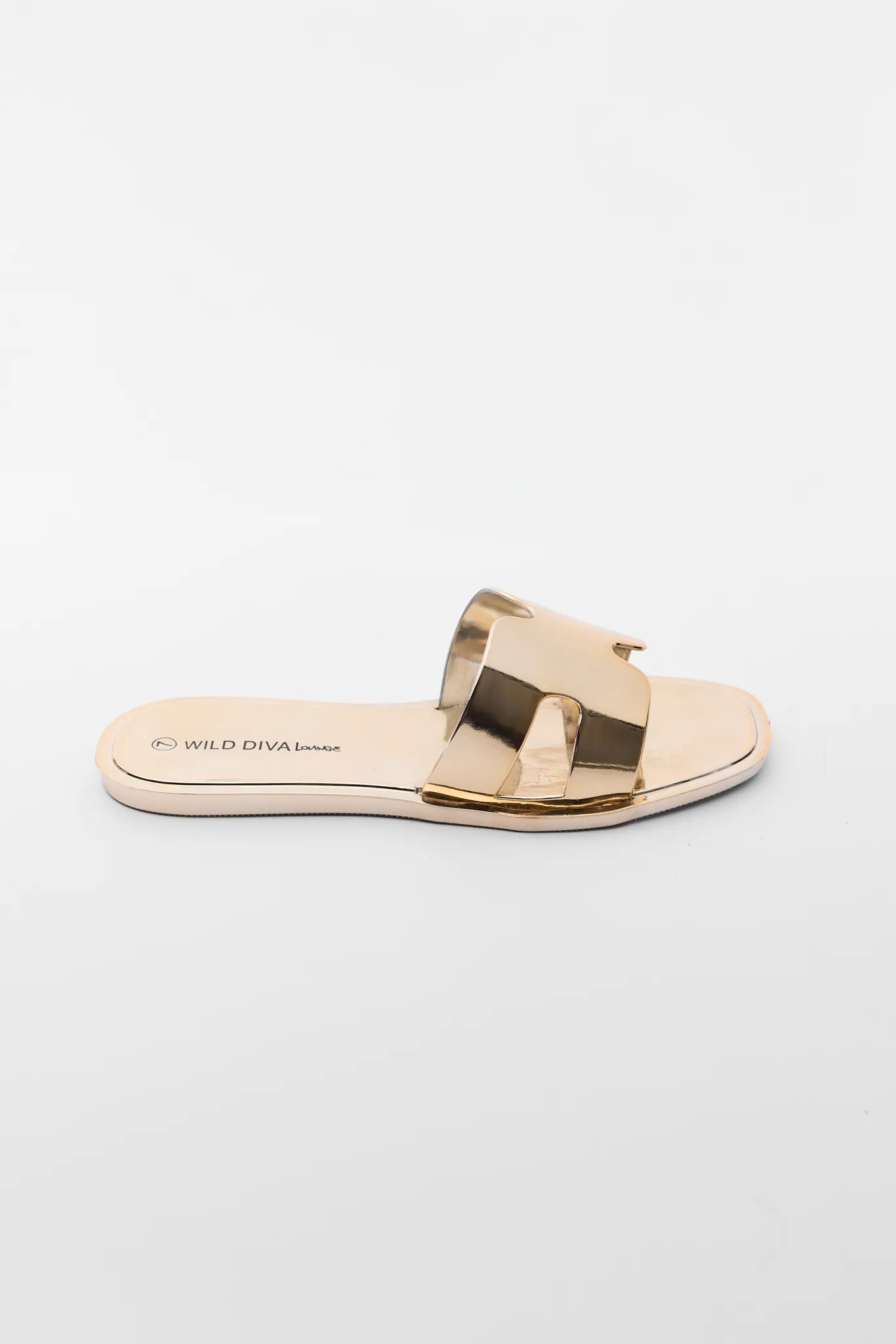 Gold sandal with a bow on a light gray background