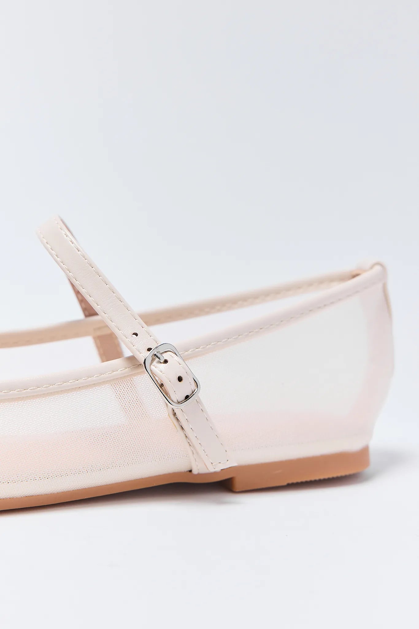 Close-up of a Jane Flats with a strap and buckle on a light gray background