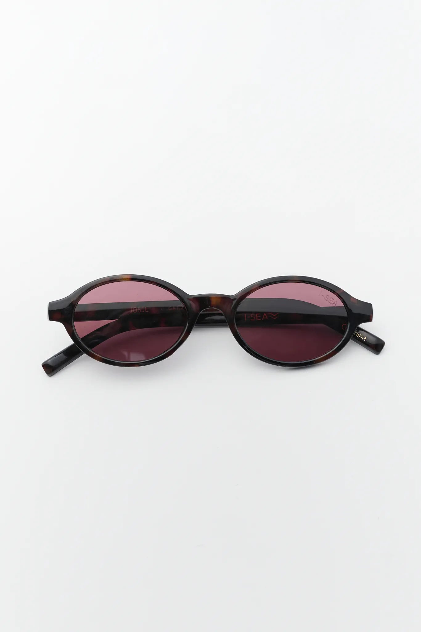 Sunglasses with dark frame and red-tinted lenses on a white background