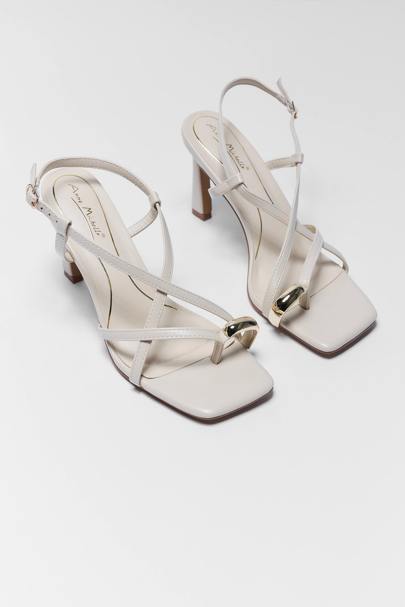 two Judith Ivory Faux Leather Strap Heels on white background