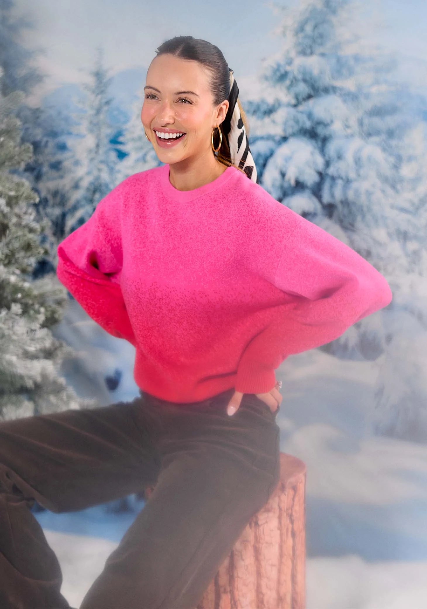 Person wearing a bright pink sweater with a blurred snowy background