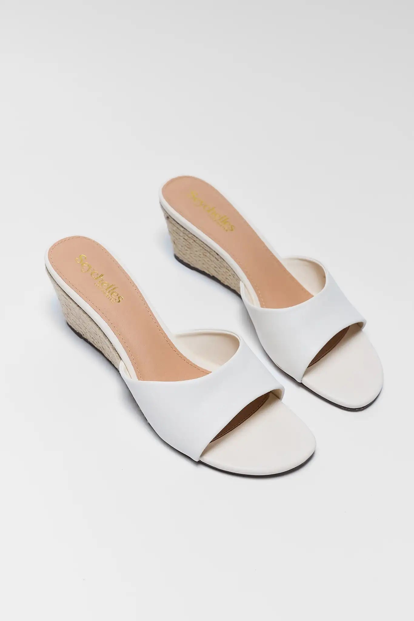 White wedge sandals on a light gray background two