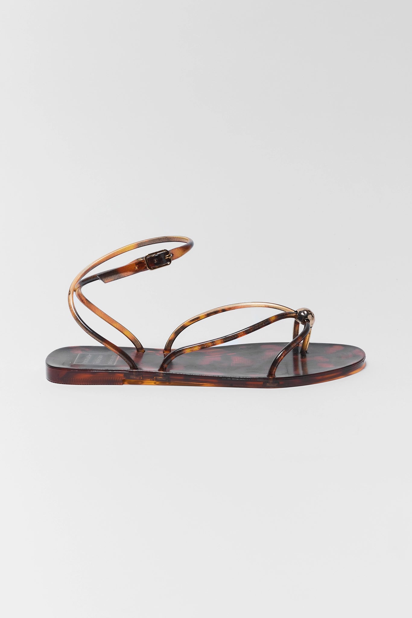 one Tortoiseshell sandal on a light gray background